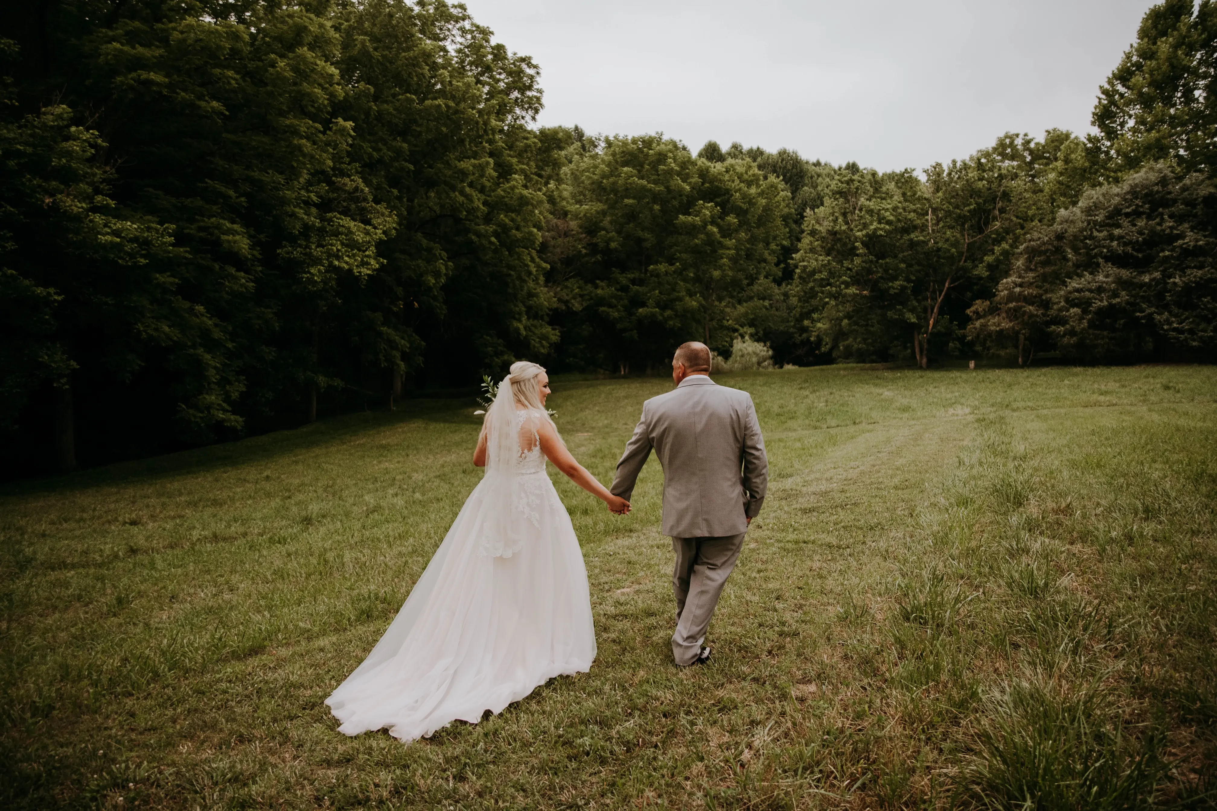 Groom and Bride at an Outdoor Wedding Wearing Lace Ballgown Wedding Dress Called Olivia by Rebecca Ingram