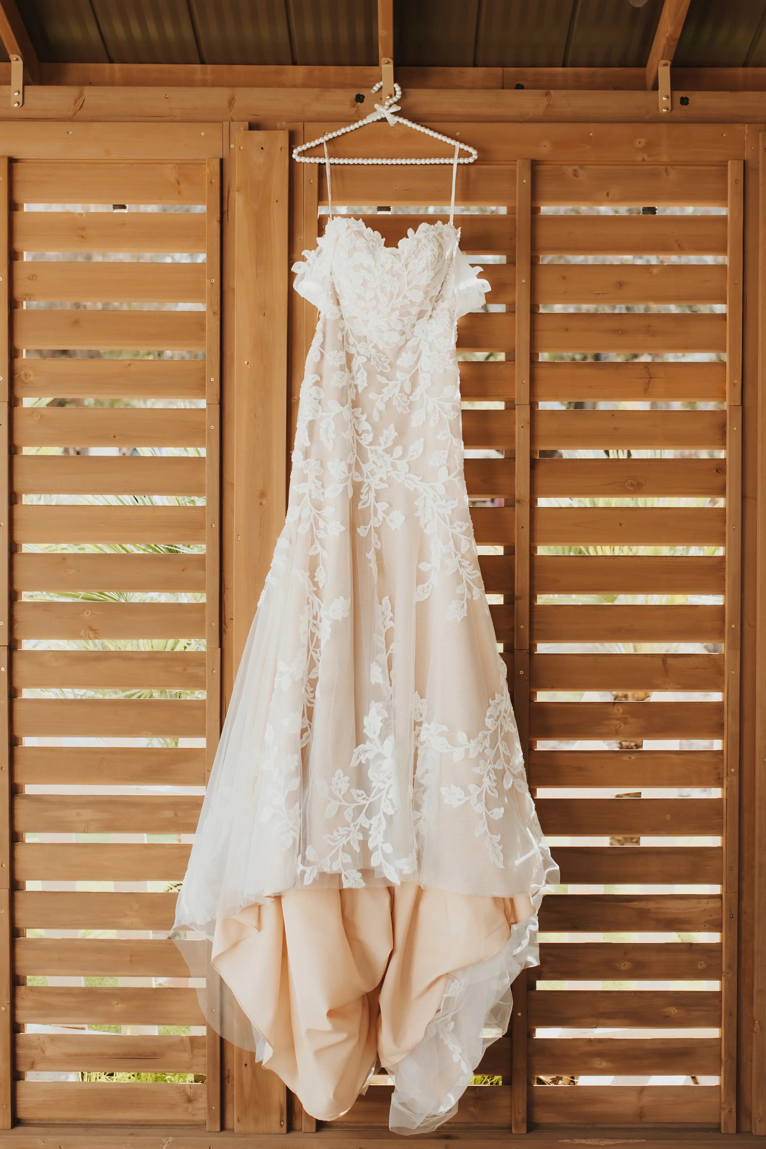 Lace Floral Wedding Dress Called Ivy By Maggie Sottero Hanging From Pearl Hanger