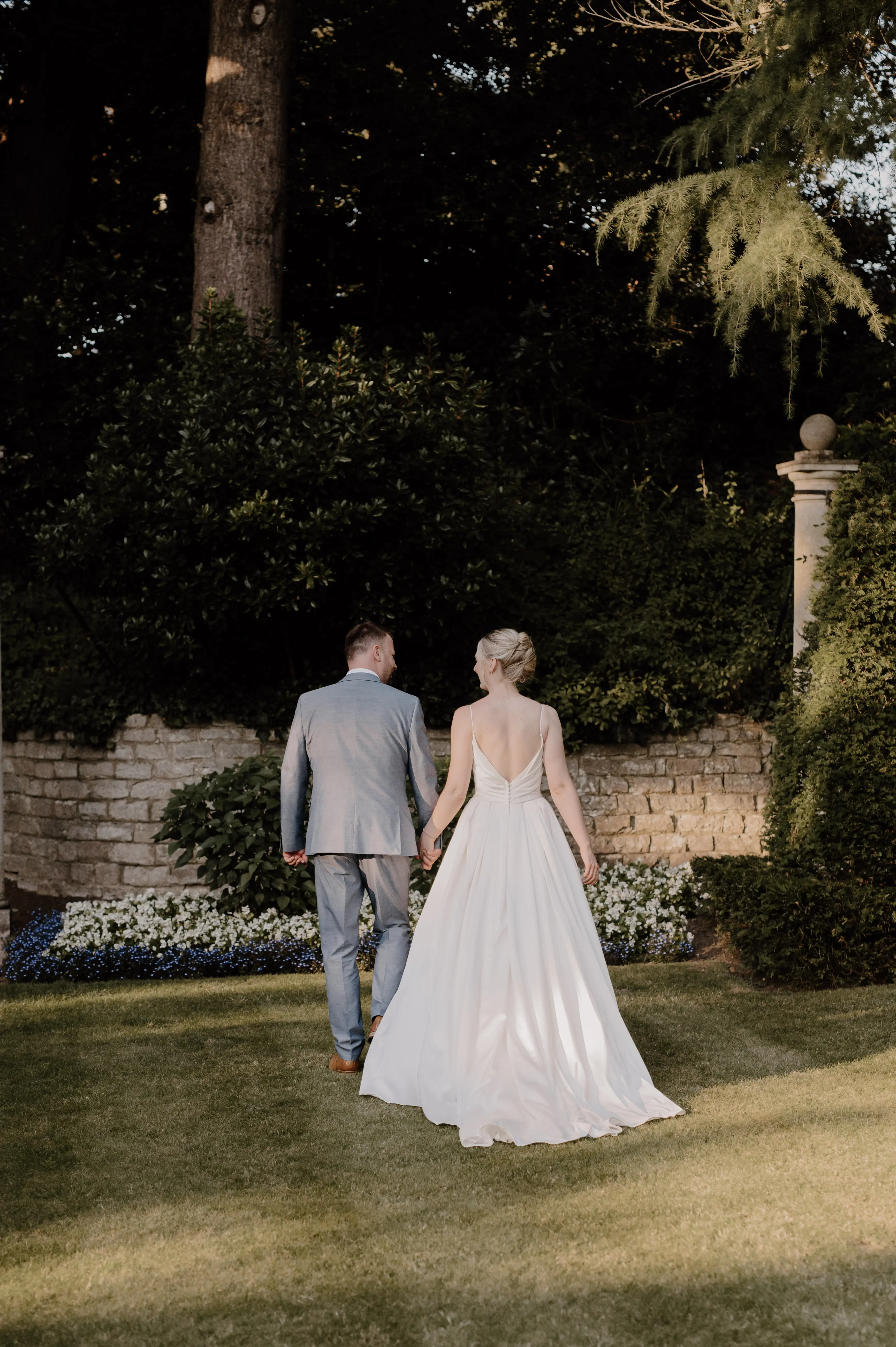 Bride wearing Scarlet by Maggie Sottero holding hands with her husband