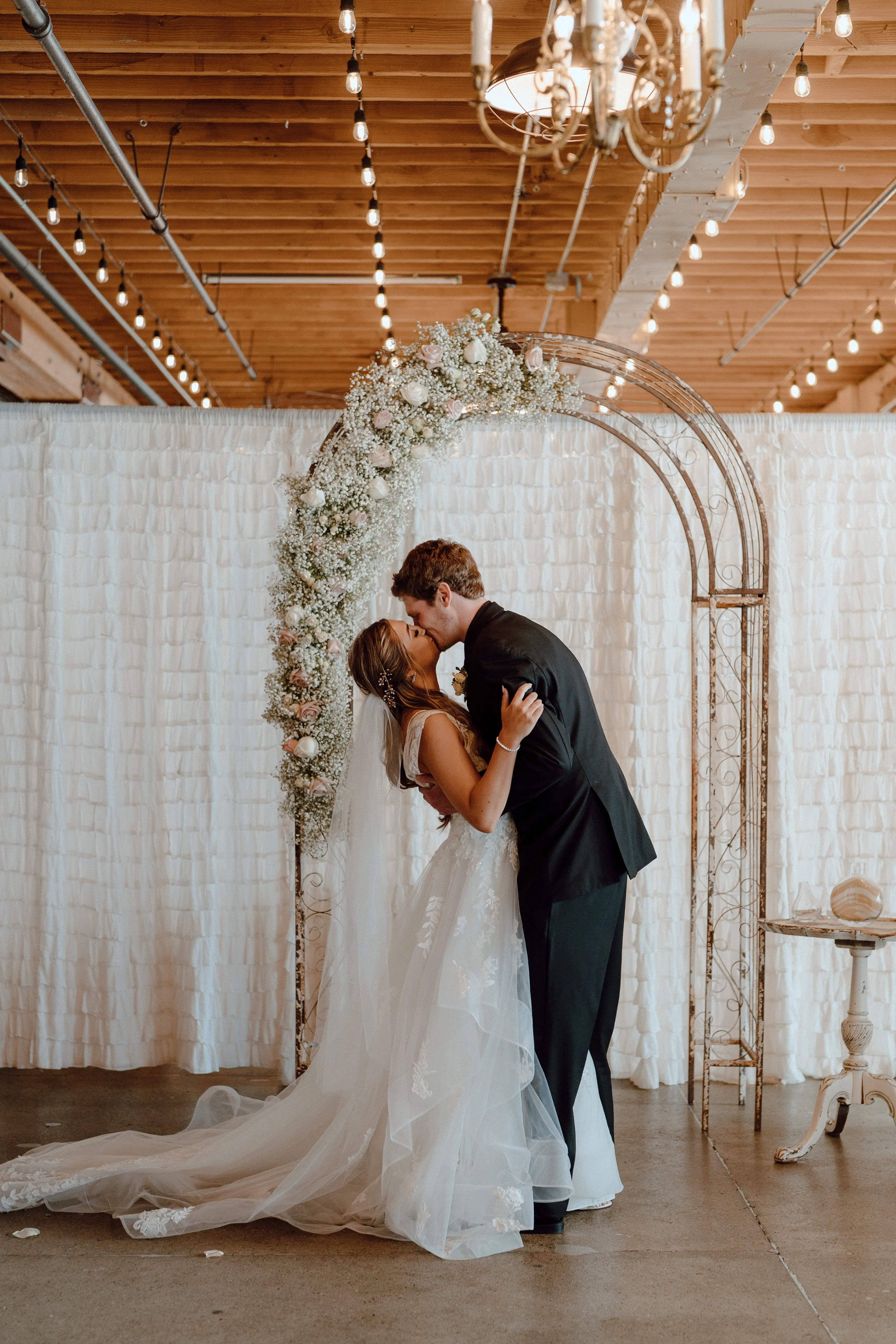 Bride in ruffle dress with illusion bodice called Lettie by Rebecca Ingram with groom