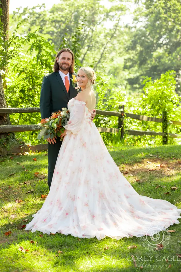 Bride wearing Nerida wedding dress by Sottero and Midgley stands with her husband