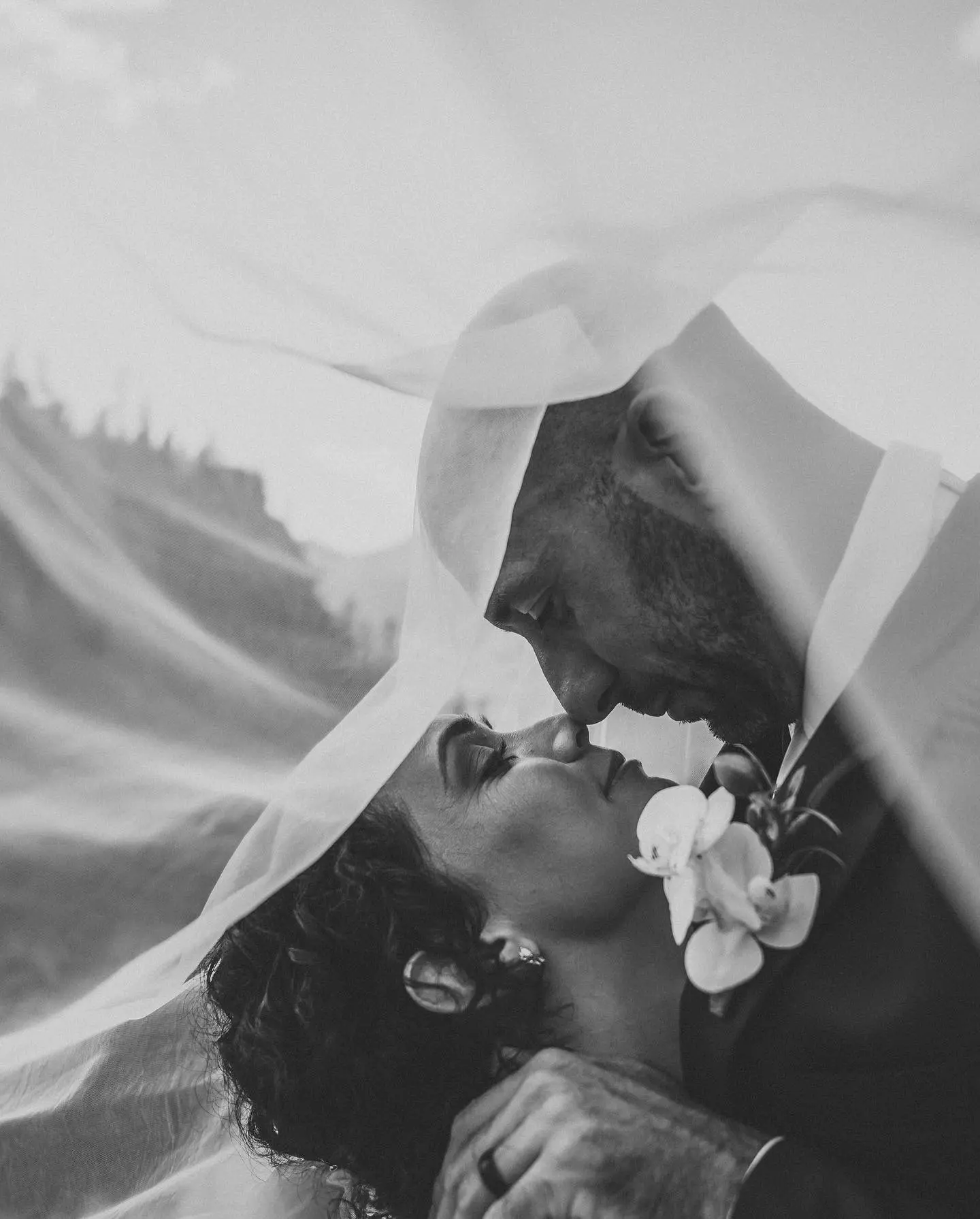 Groom and Bride Under Veil in the Mountains Wearing Wedding Dress Called Joanne by Rebecca Ingram.
