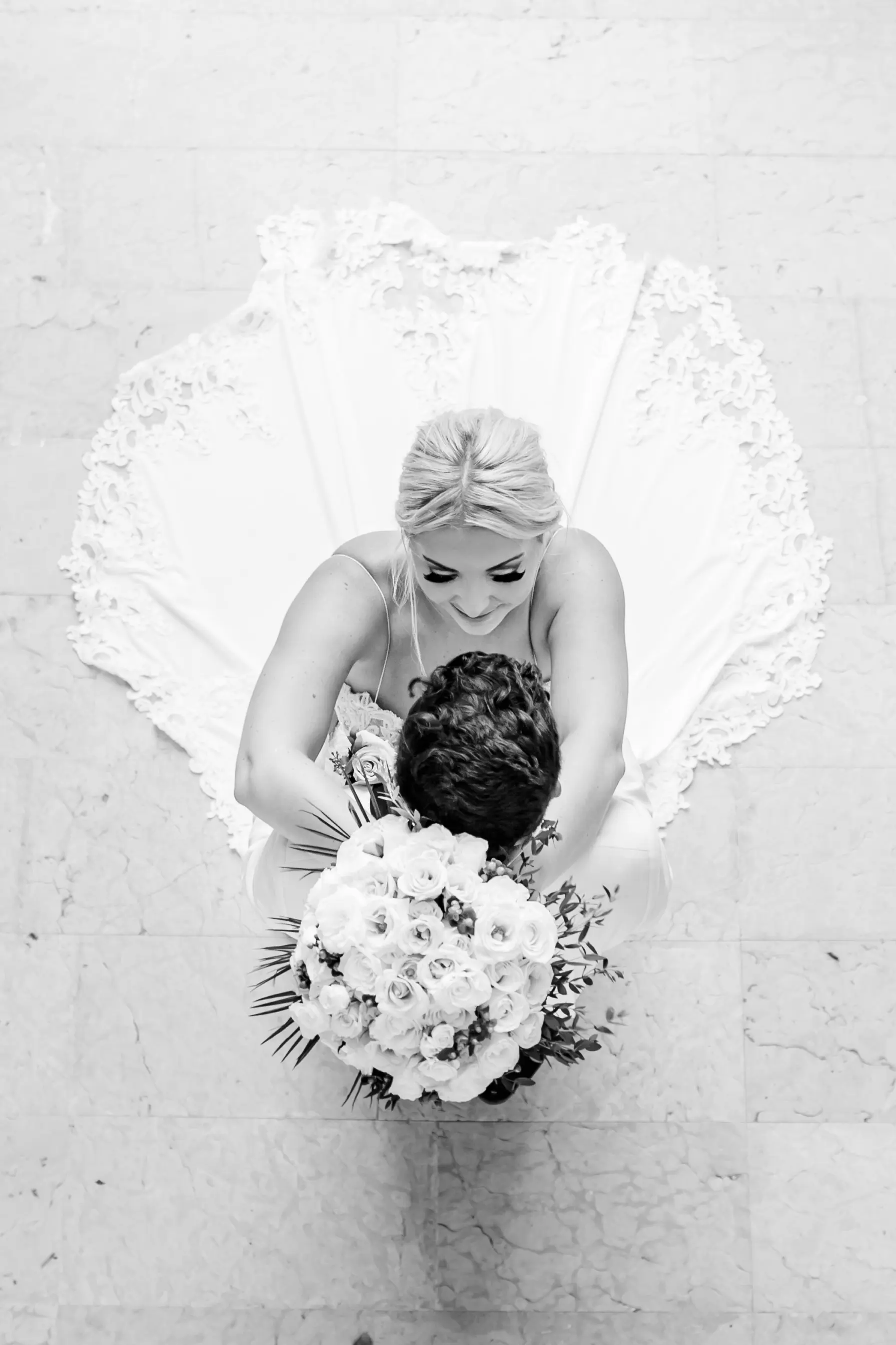 View from above of bride with arms around her husband.