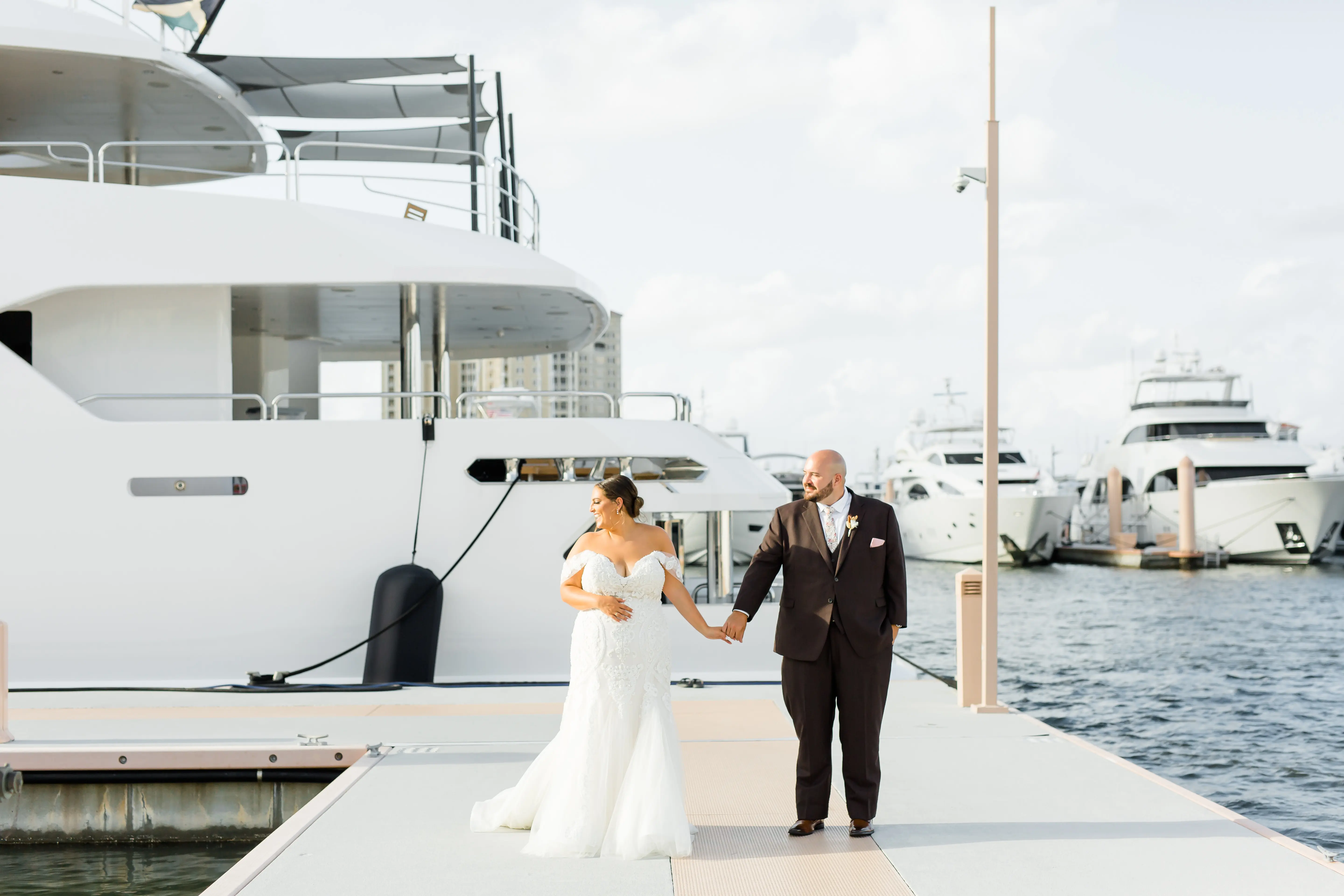 Bride with groom wearing off-the-shoulder mermaid wedding dress.