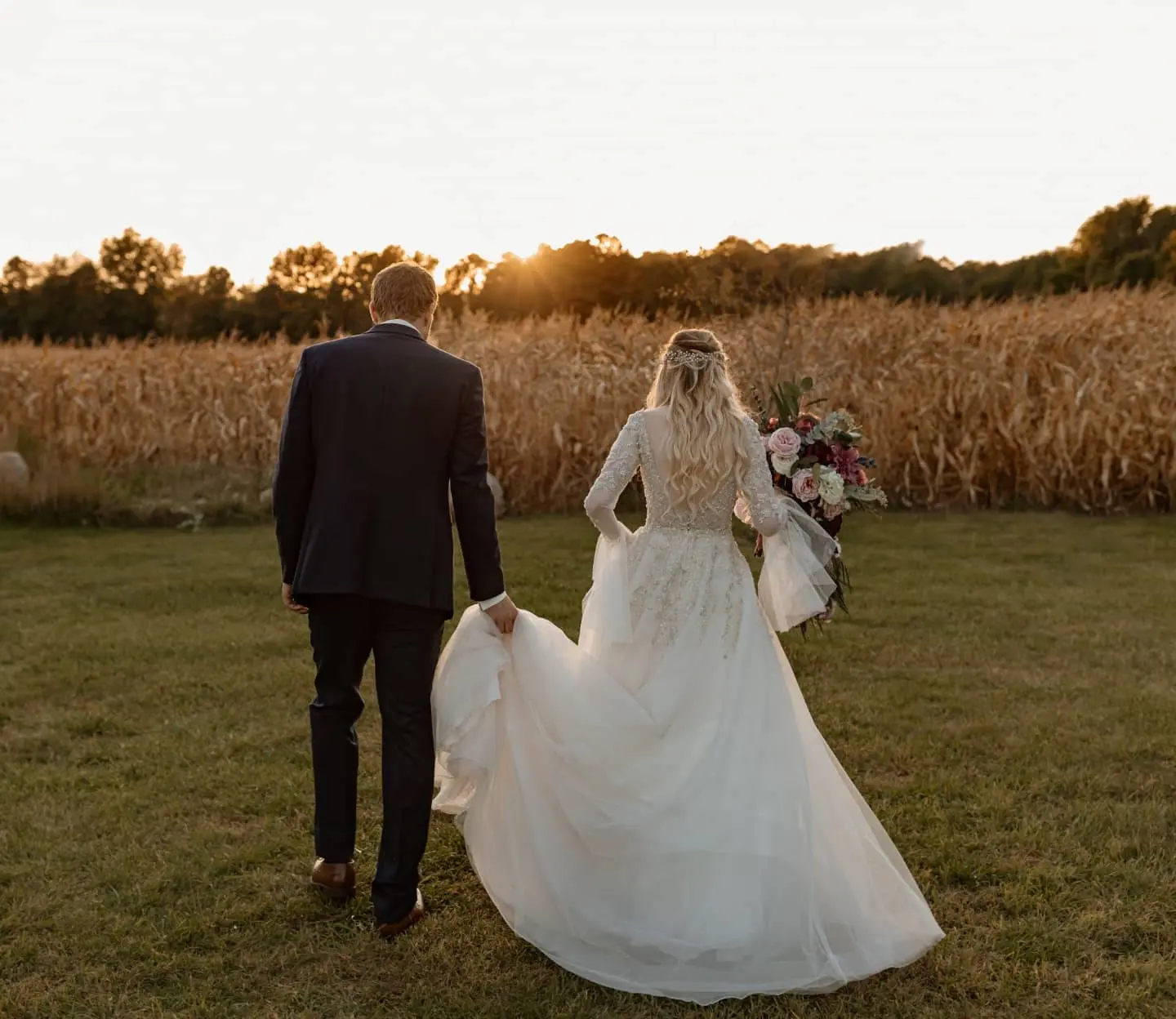 Newlyweds walking towards sunset.