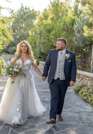 Groom and Bride Holding Hands Wearing Wedding Dress Called Hattie Lane Marie by Rebecca Ingram.