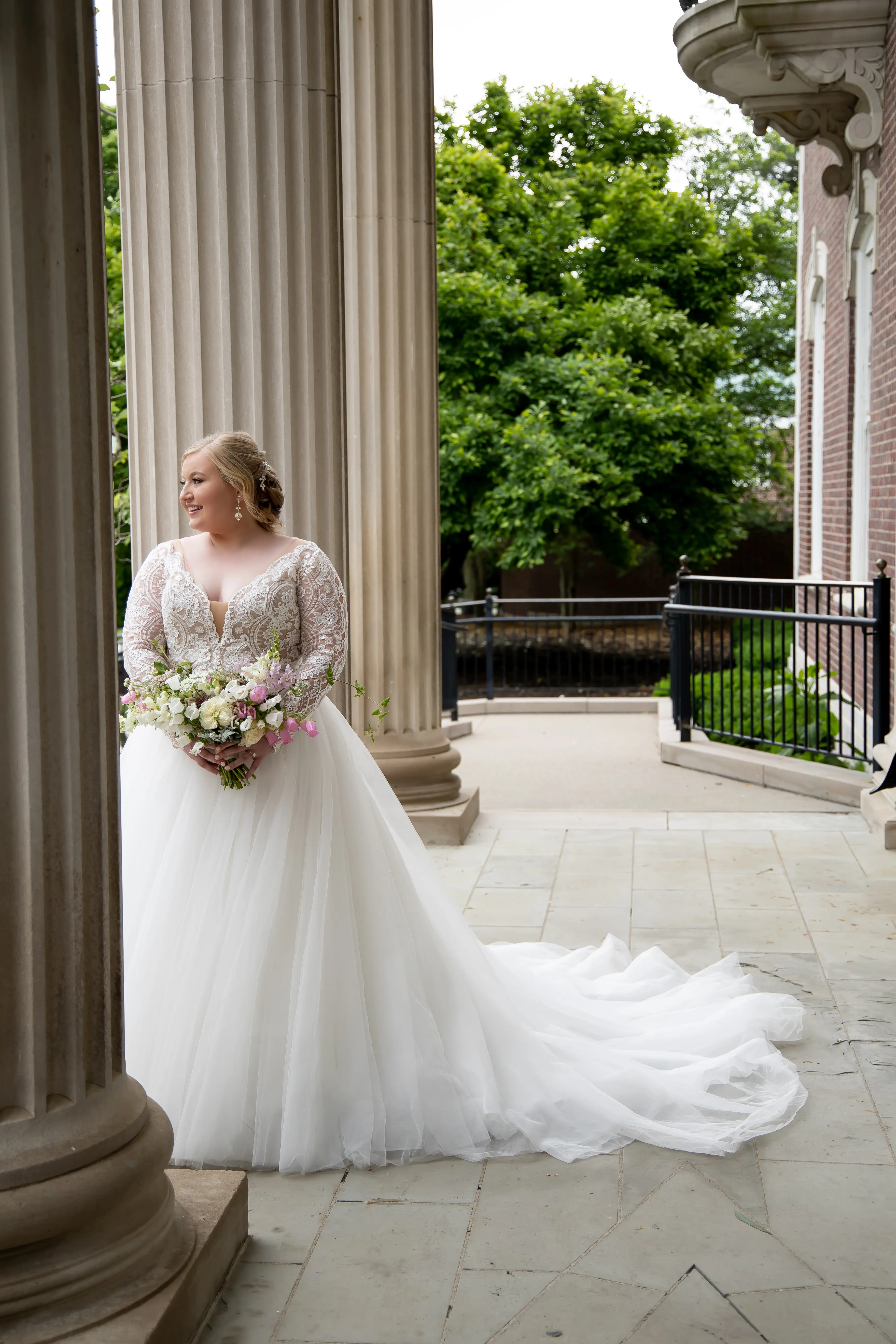 Bride Standing Outside Holding Wedding Bouquet Wearing Wedding Dress Called Mallory Dawn by Maggie Sottero