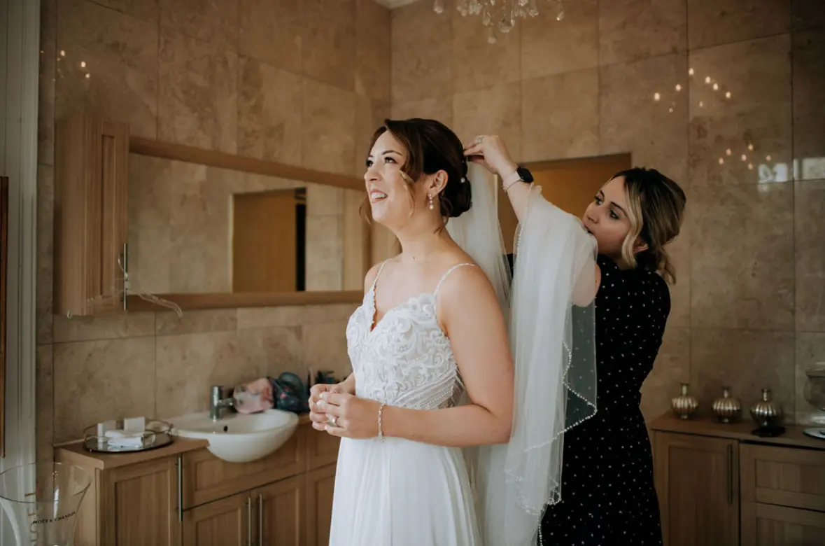 Bride wearing Lorraine by Rebecca Ingram getting her hair done