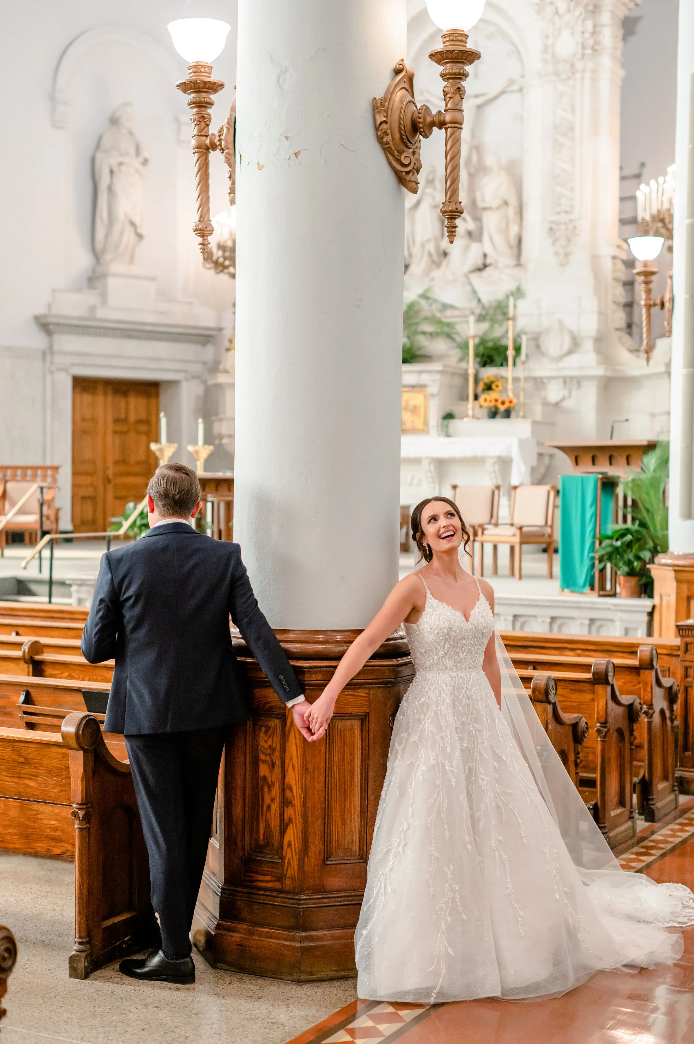 Bride wearing Marvine wedding gown by Sottero and Midgley while holding hands with her husband