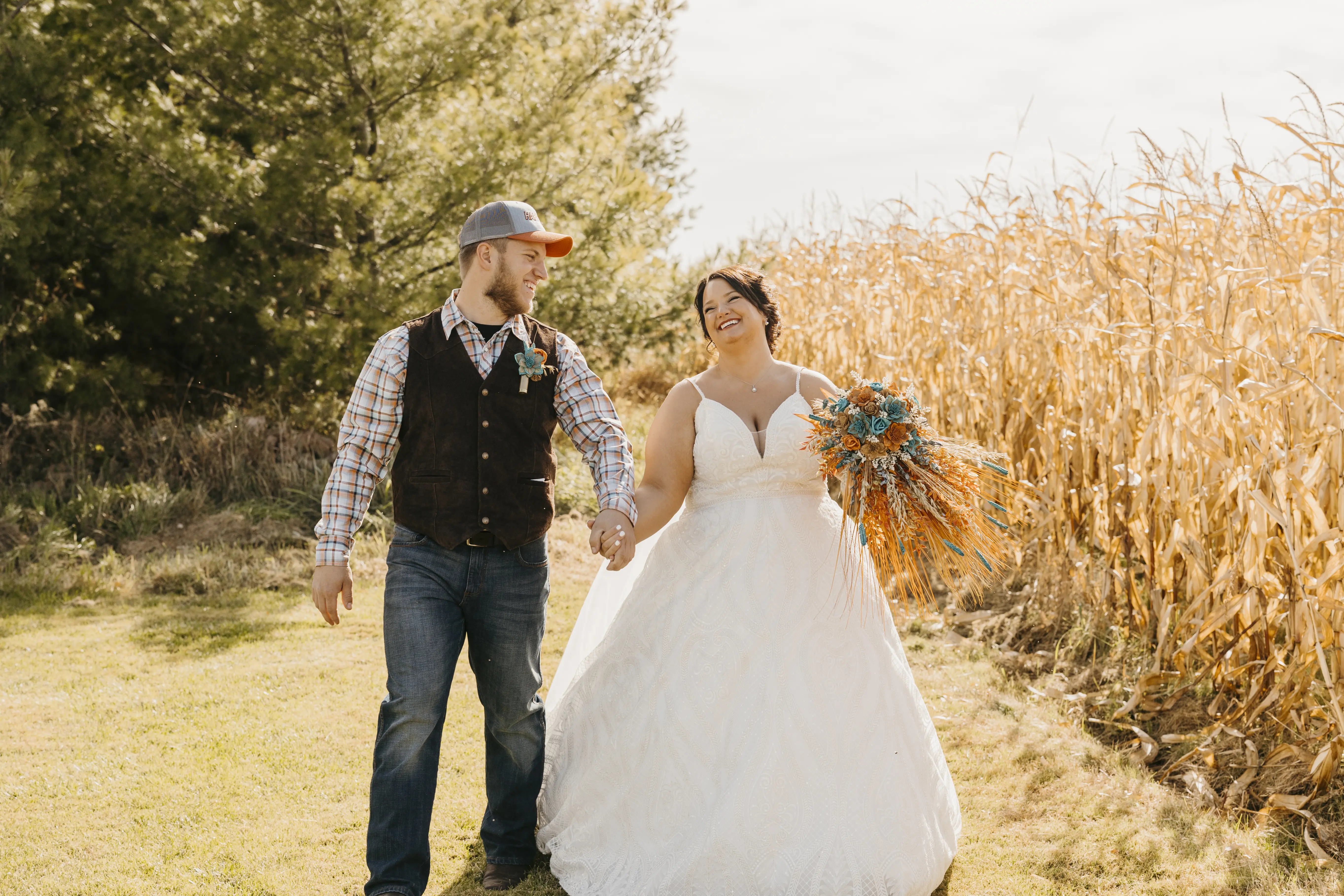 Groom Walking Hand in Hand through the Corn Fields with Bride in Deep V-Neckline Wedding Dress Called Roxanne by Sottero & Midgley