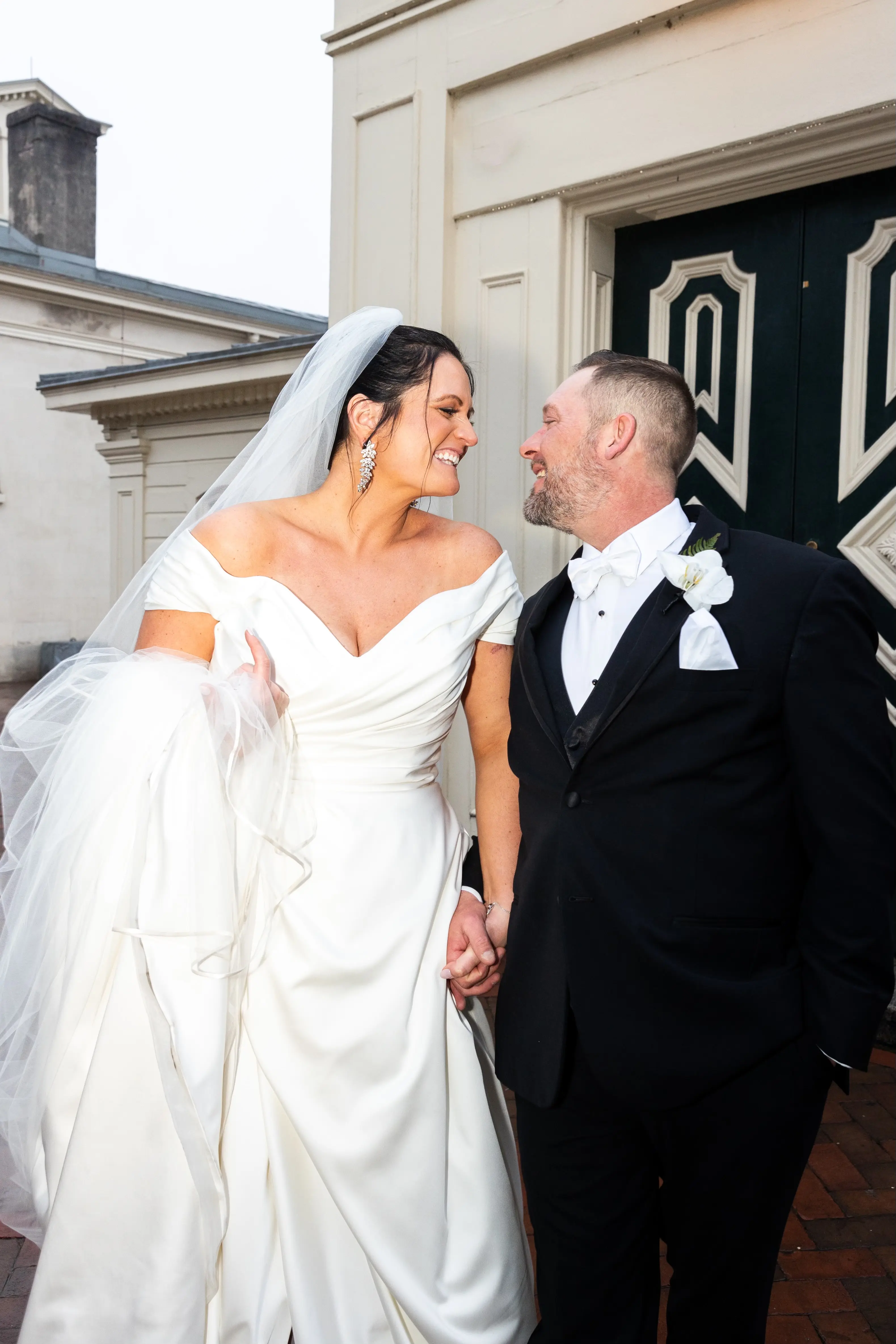 Bride wearing Ekaterina by Maggie Sottero holding hands with her husband