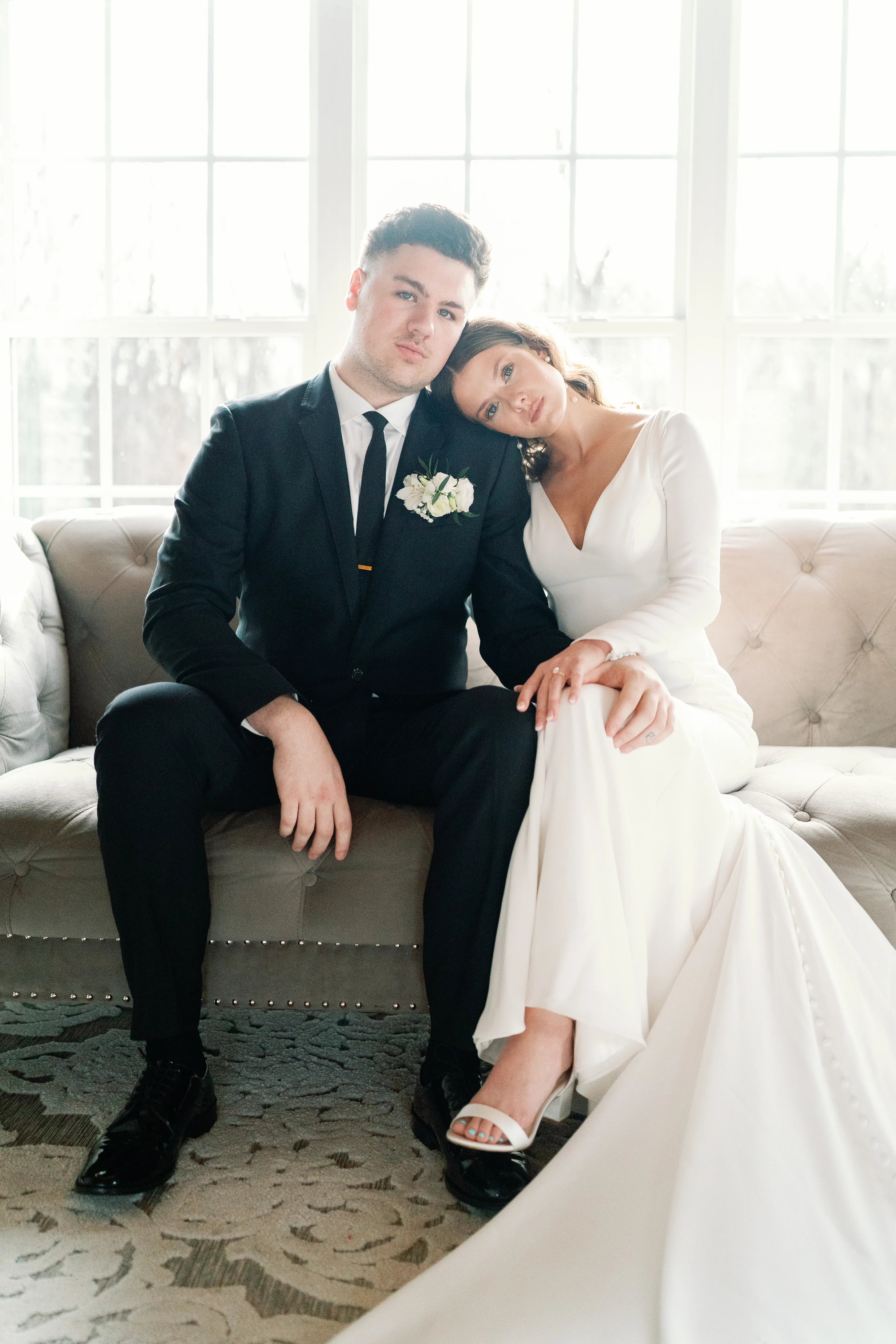 Bride wearing Fernanda wedding dress by Maggie Sottero sitting with her husband