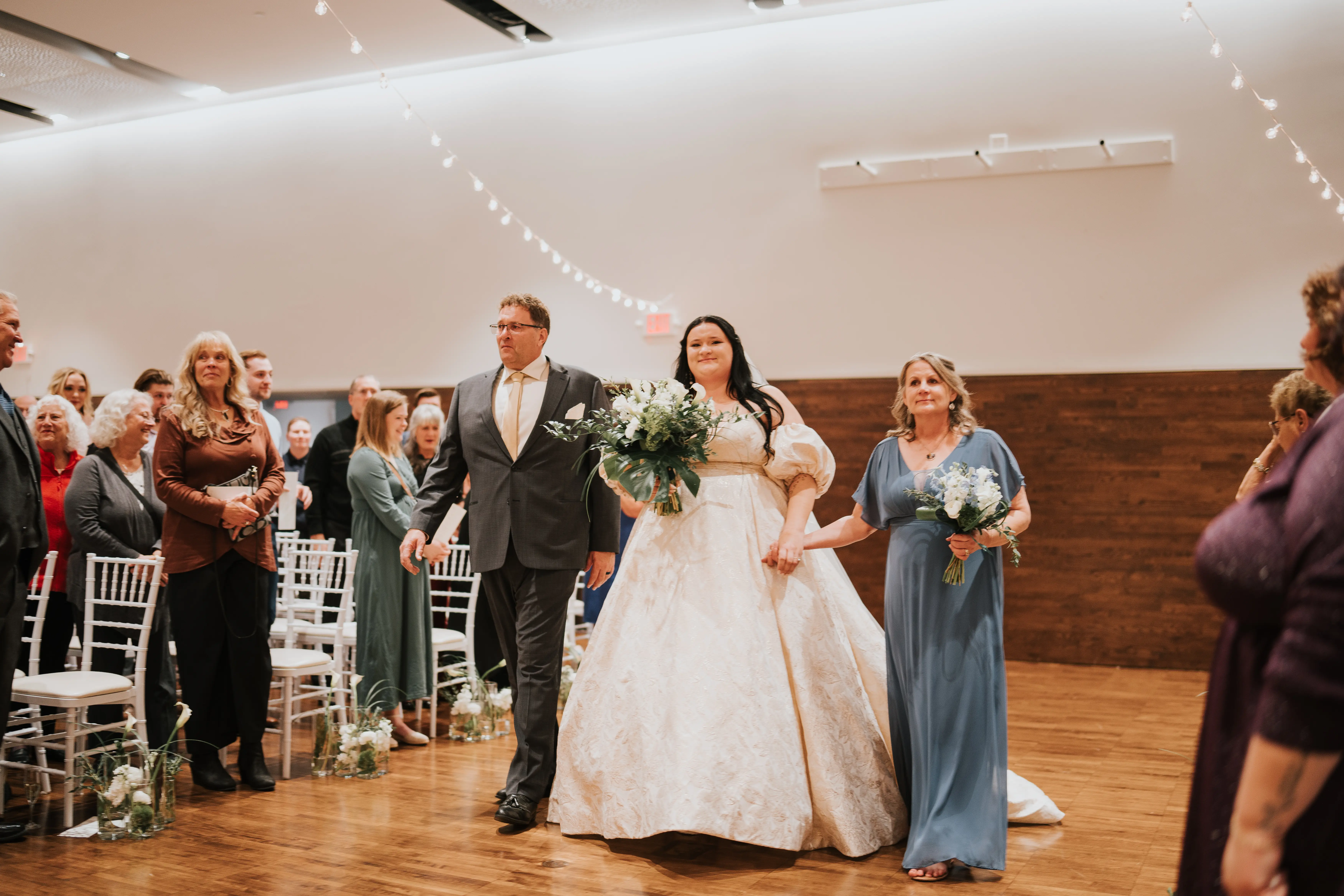 Bride Wearing Floral Jacquard Princess Wedding Gown Called Cyprus By Sottero And Midgley Walking Down The Aisle With Her Parents