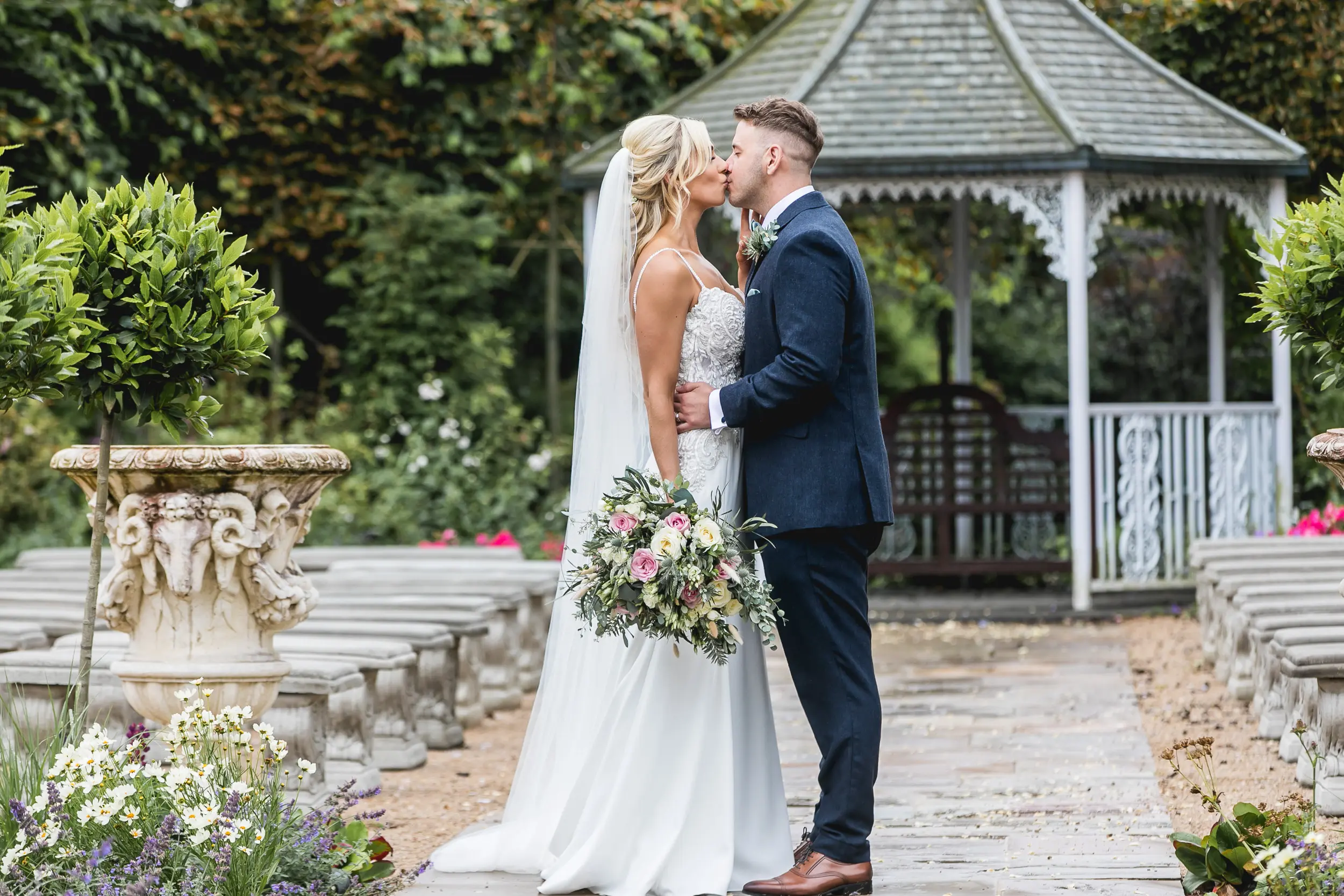 Bride and groom kissing in the aisle.