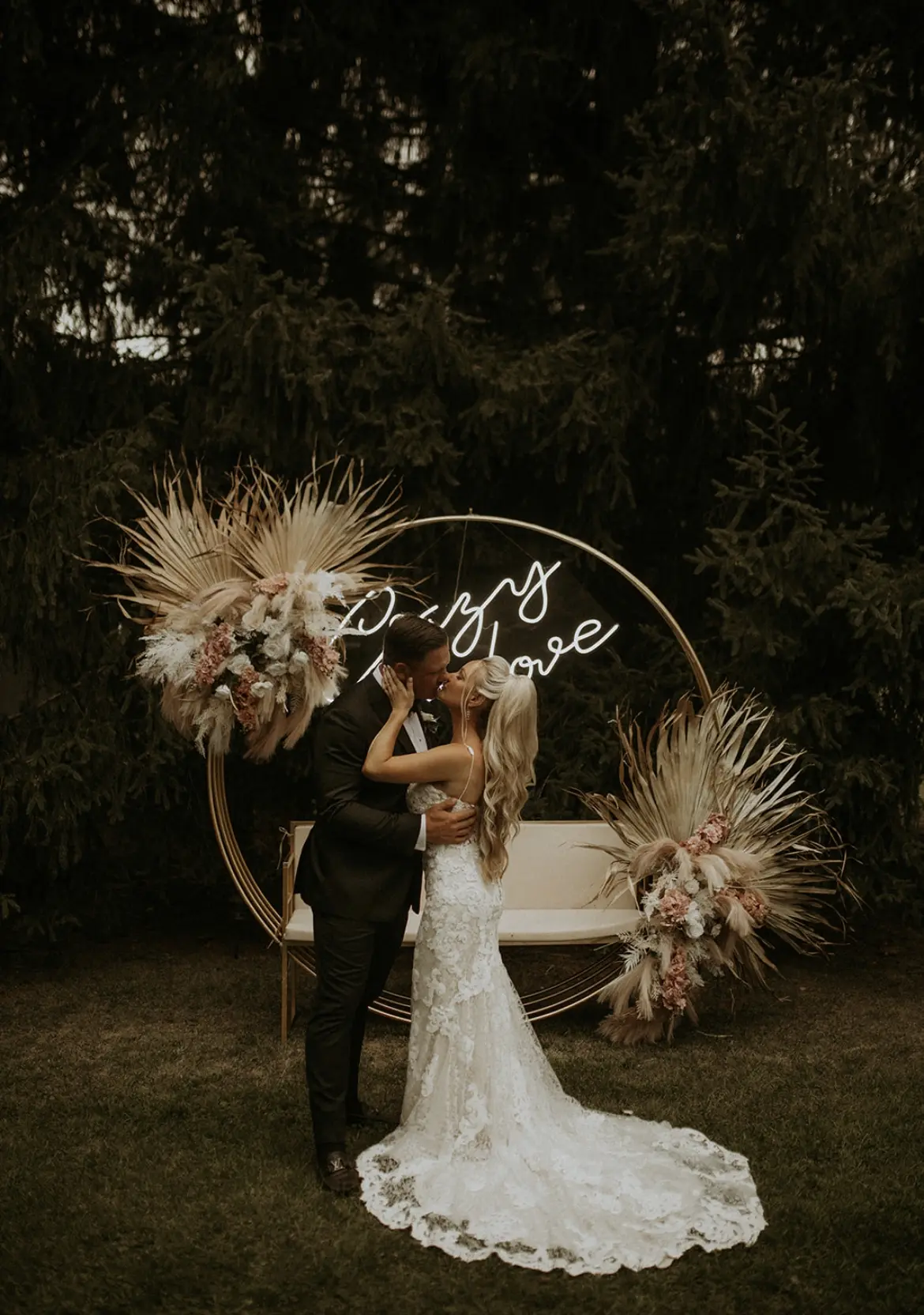 Bride wearing Lace Fit-and-Flare Wedding Dress called Tuscany Lynette by Maggie Sottero kissing the groom