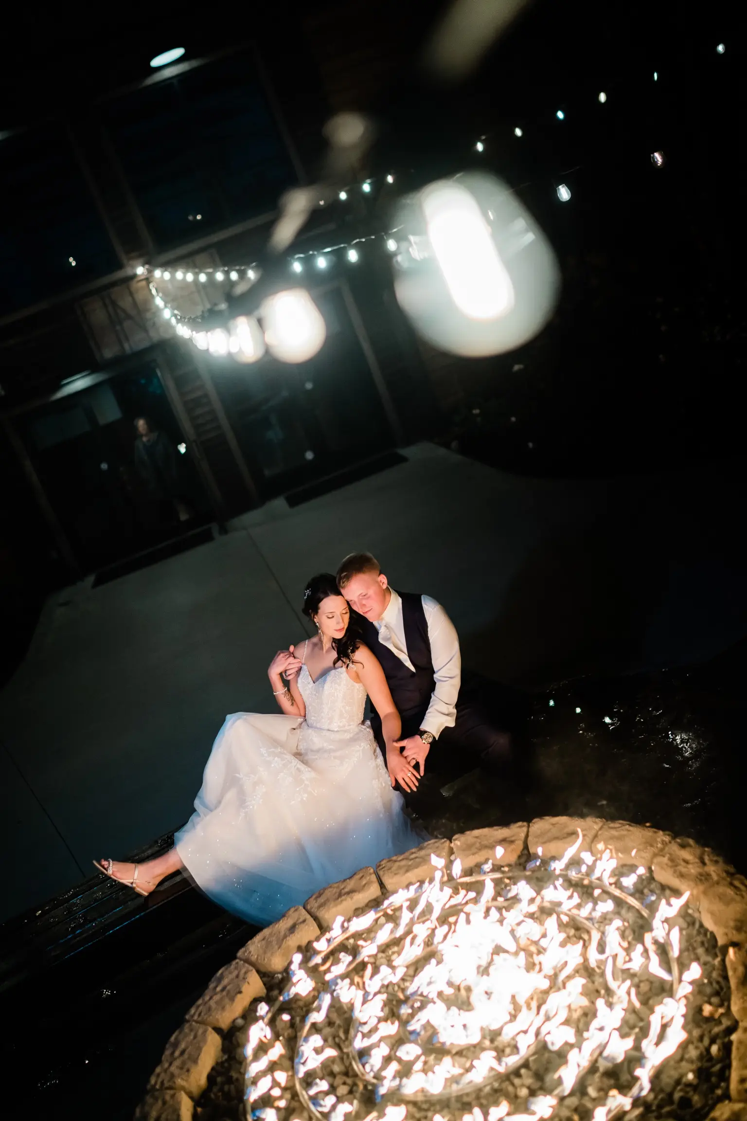 Bride Wearing Ballerina-inspired Romantic Wedding Dress Called Fairbanks By Maggie Sottero And Groom Sitting Around A Fire