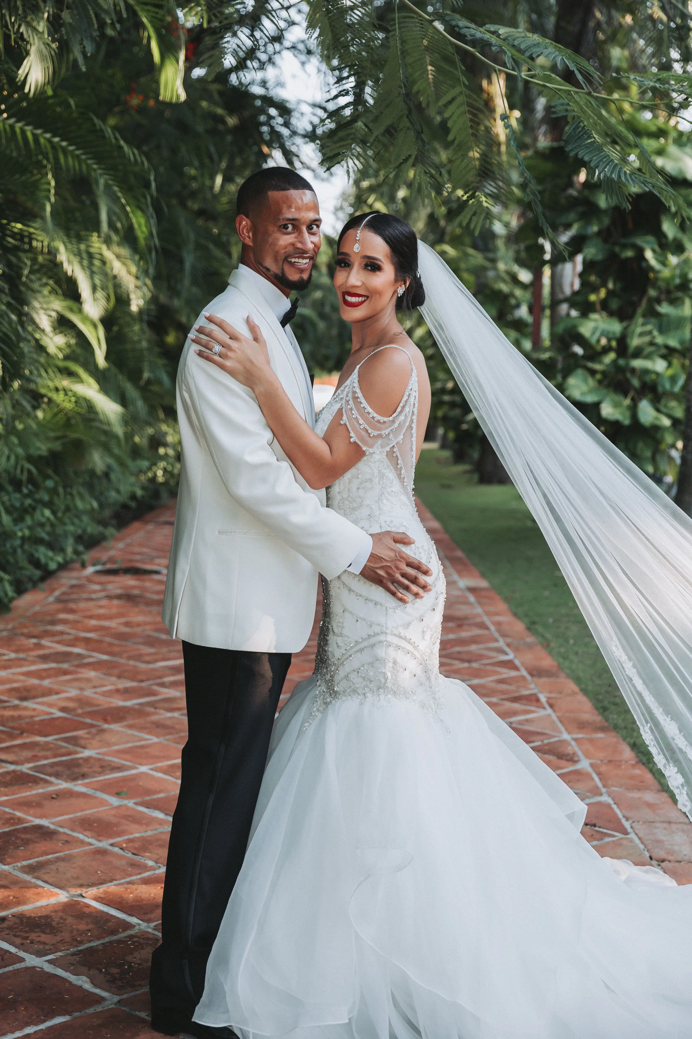 Bride with groom wearing glamorous mermaid wedding dress