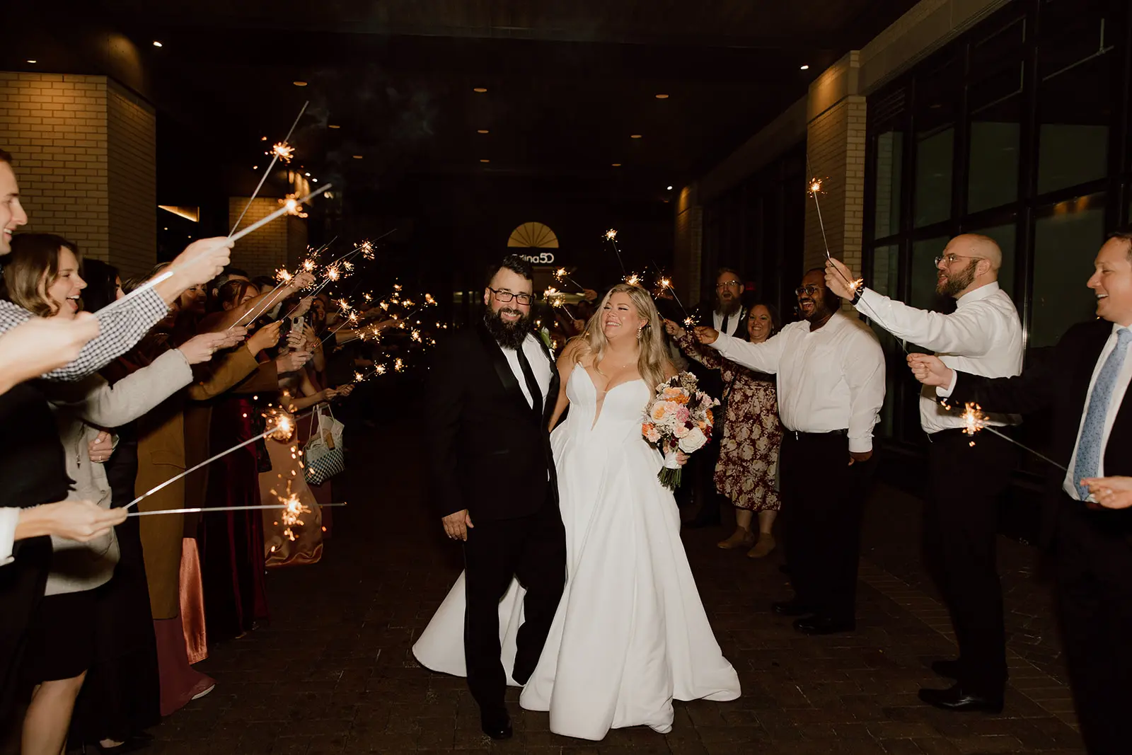 Bride wearing Derrick by Maggie Sottero and her husband during their exit