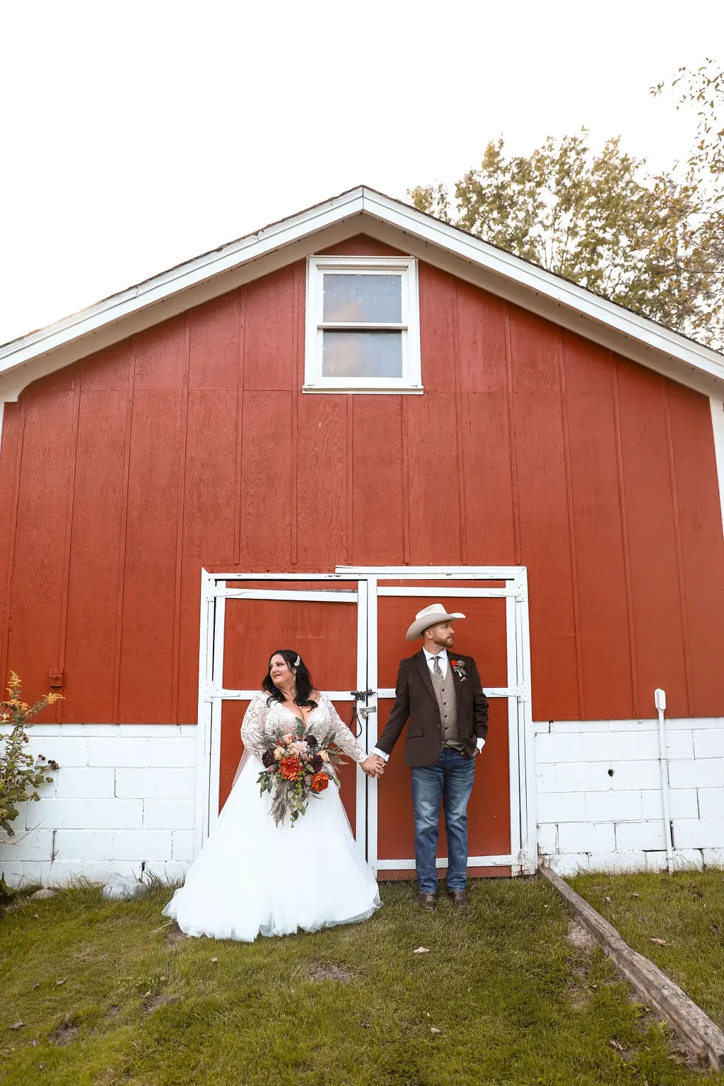Bride wearing Princess Ballgown Wedding Dress called Mallory Dawn by Maggie Sottero and groom in front of a red barn
