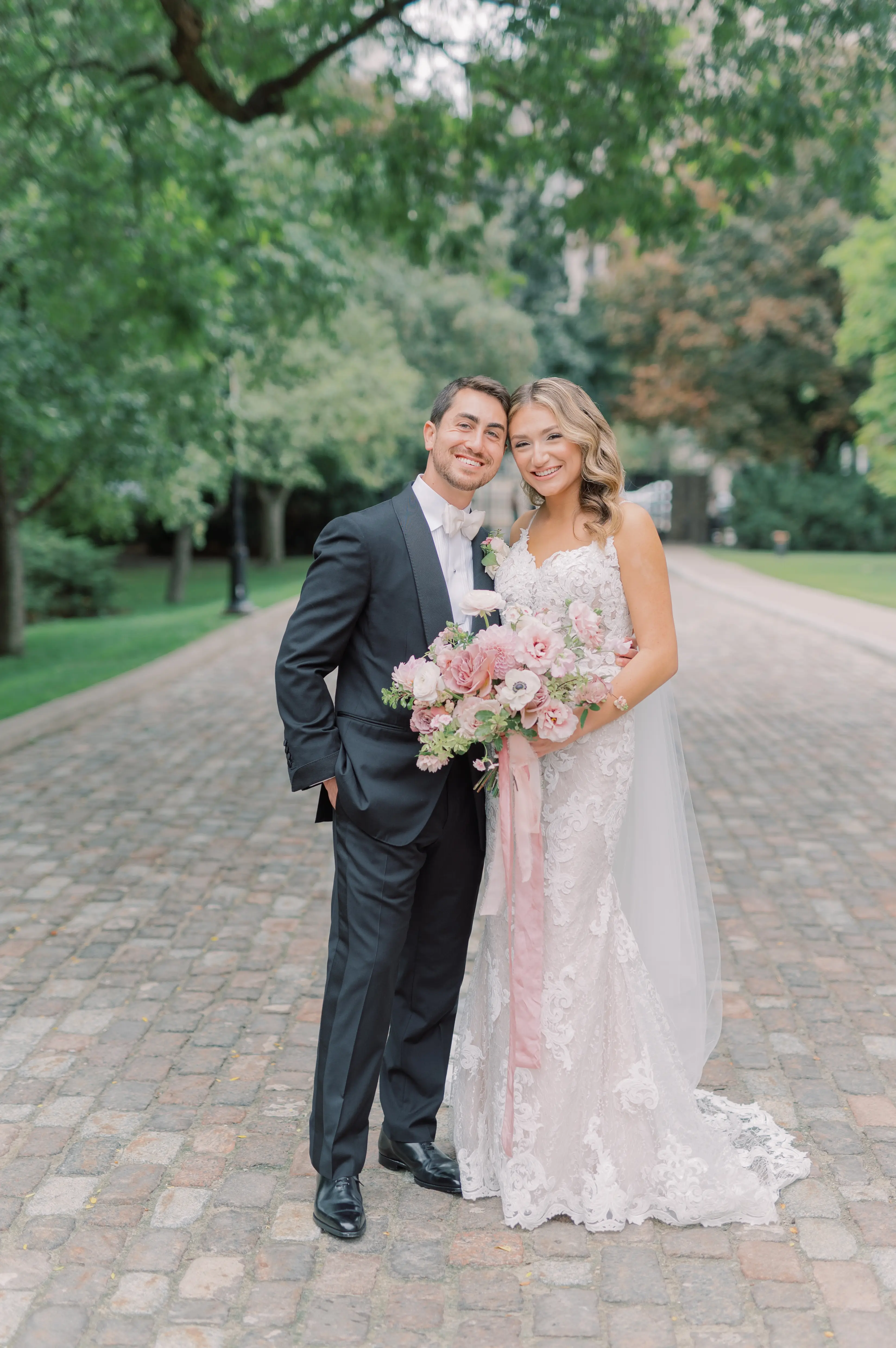 Bride Wearing A Lace Sheath Wedding Gown Named Tuscany Lynette By Maggie Sottero Bride and Groom With Flowers