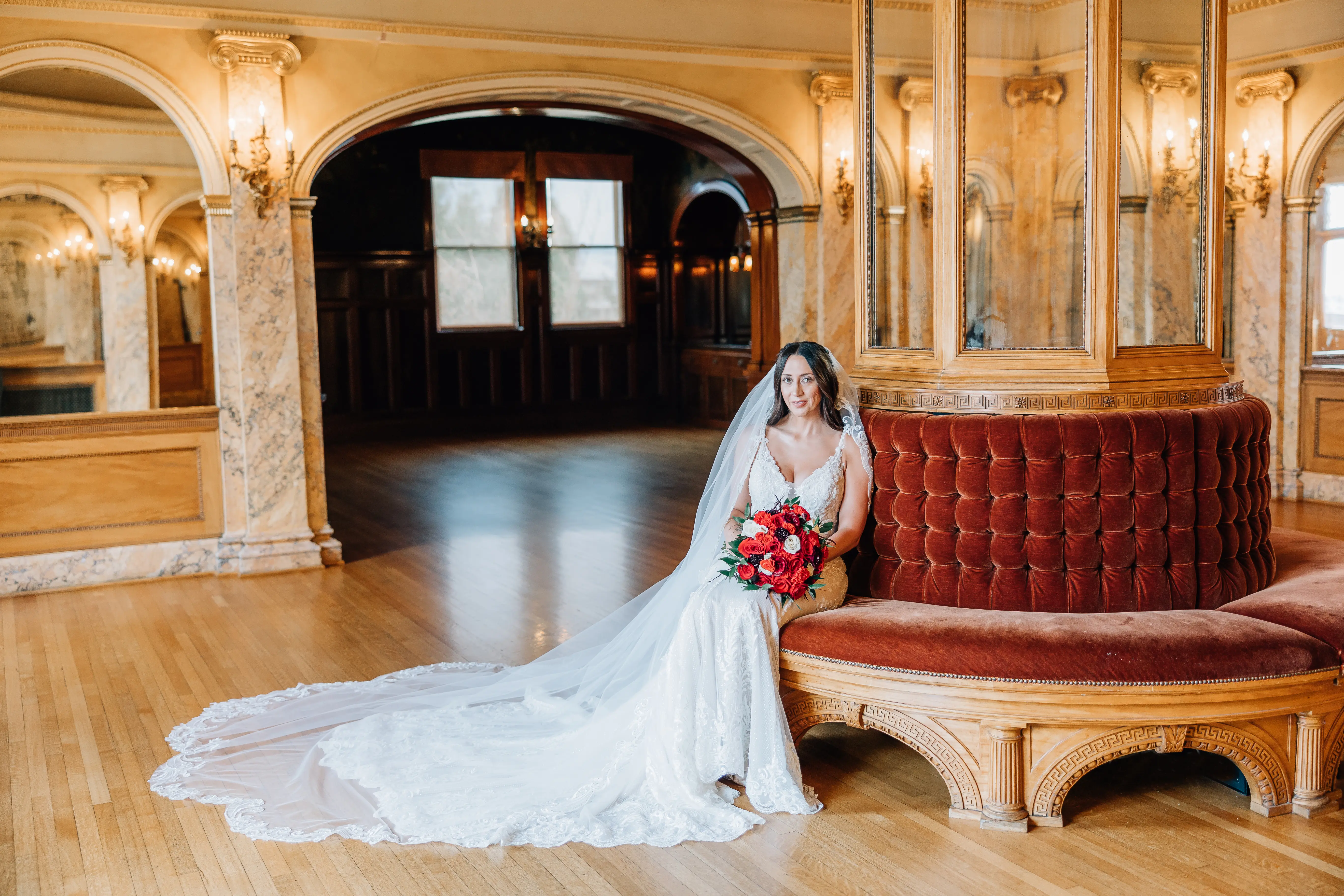 Real Bride Wearing A Fitted White Wedding Dress Named Veronique by Maggie Sottero Holding Red Roses