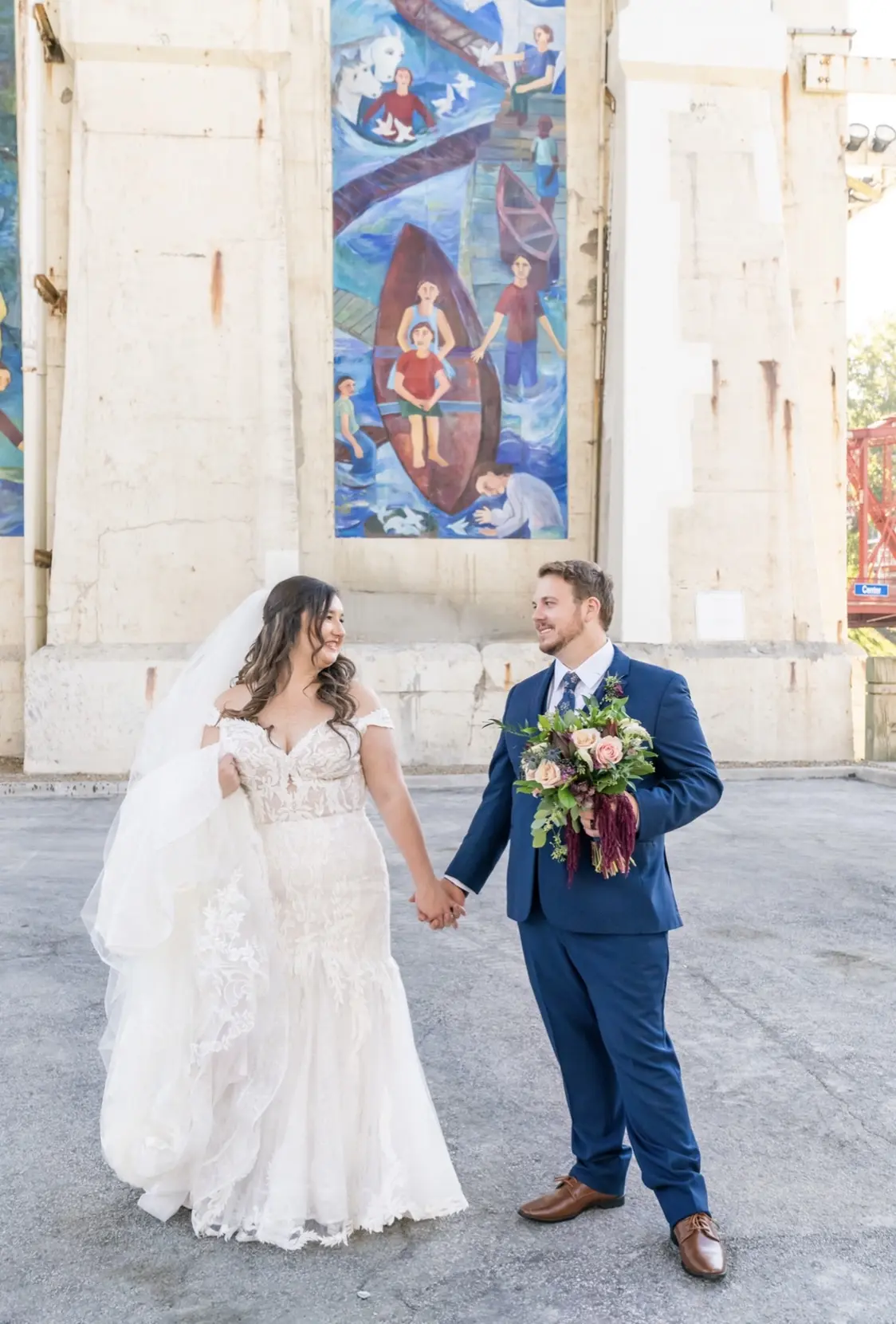 Bride with groom wearing cap sleeve lace mermaid wedding dress.