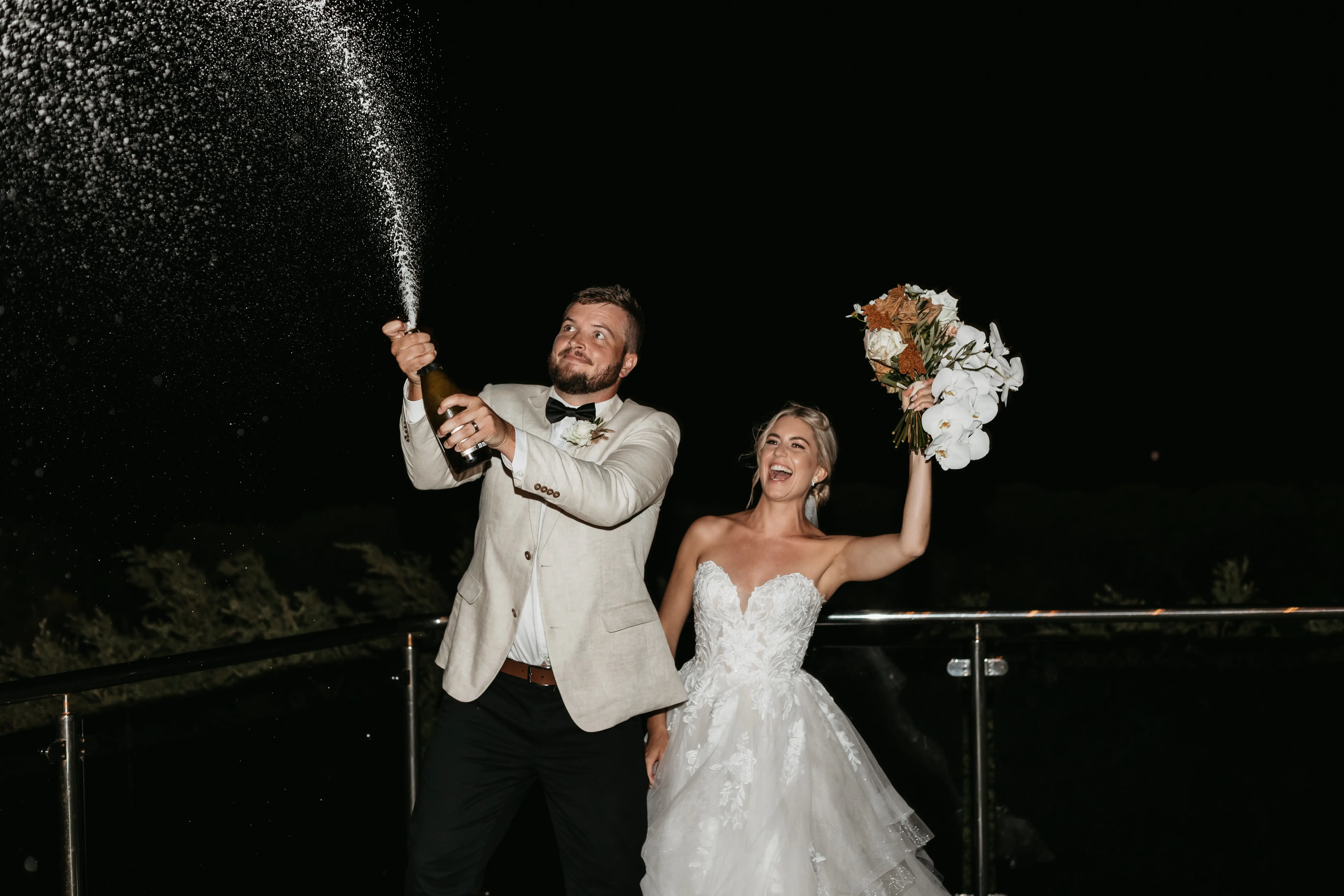 Bride wearing Indiana by Maggie Sottero and her husband spraying alcohol