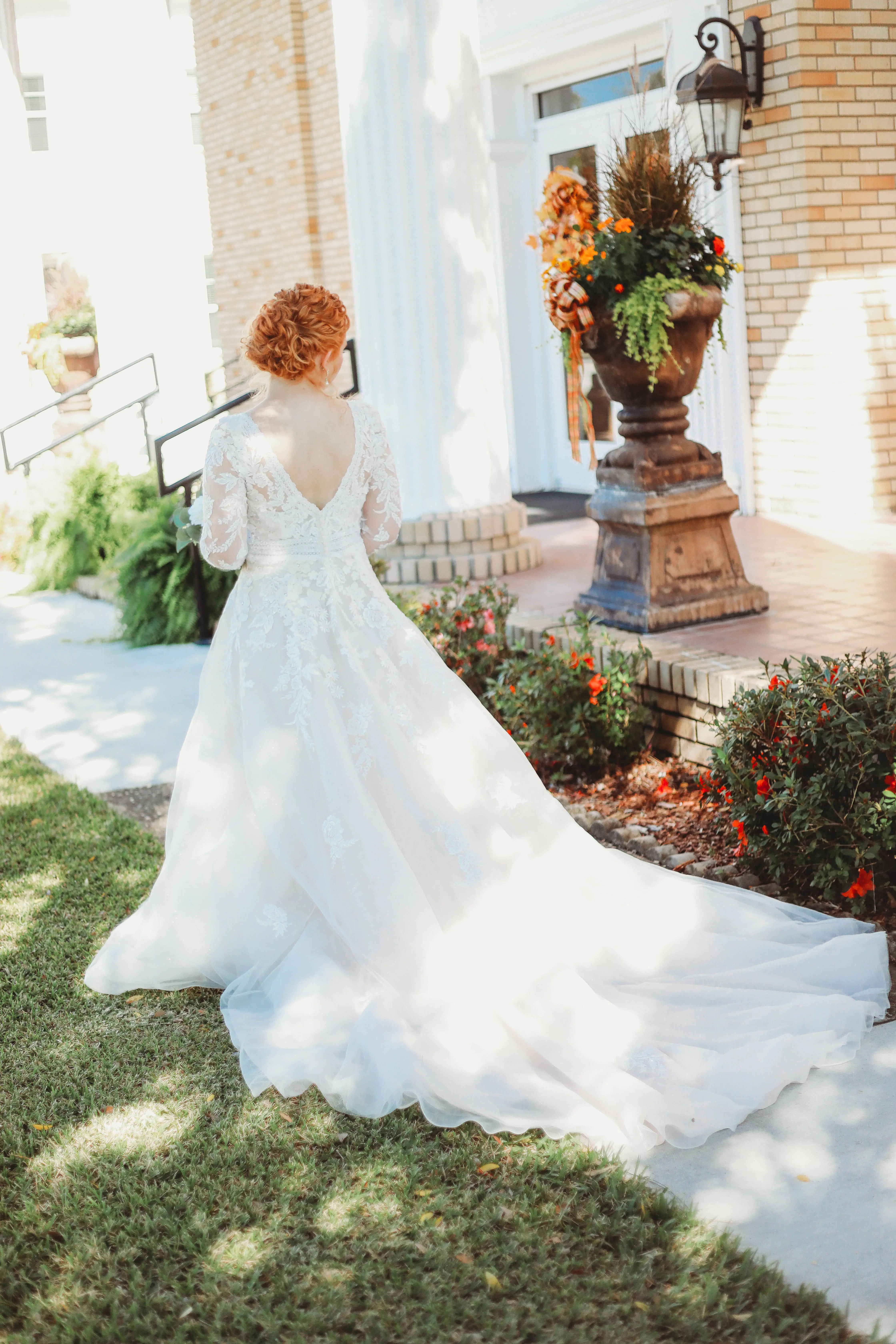 Bride Wearing Low-Back Wedding Dress With Long-Sleeves And Floral Lace Details Called Raphael By Maggie Sottero