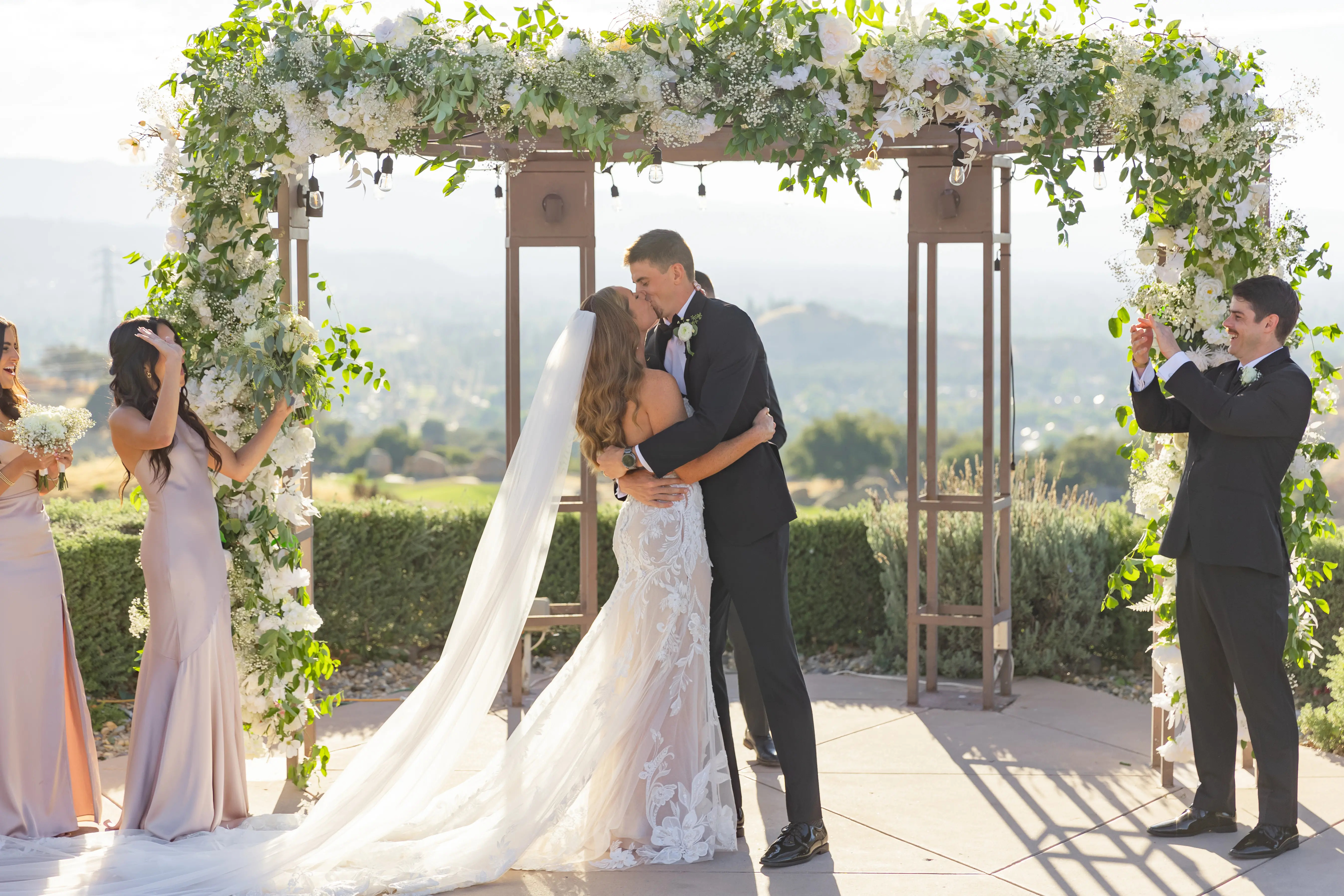 Bride Wearing Lace Fit-n-flare Wedding Dress Called Nyjah By Sottero And Midgley Kissing Groom After Ceremony