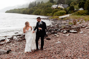 Bride and Groom Stroll the Beaches of Scotland. Bride in Romantic Lace Sheath Wedding Gown with Shimmering Lace Motifs Called Tuscany Lynette by Maggie Sottero