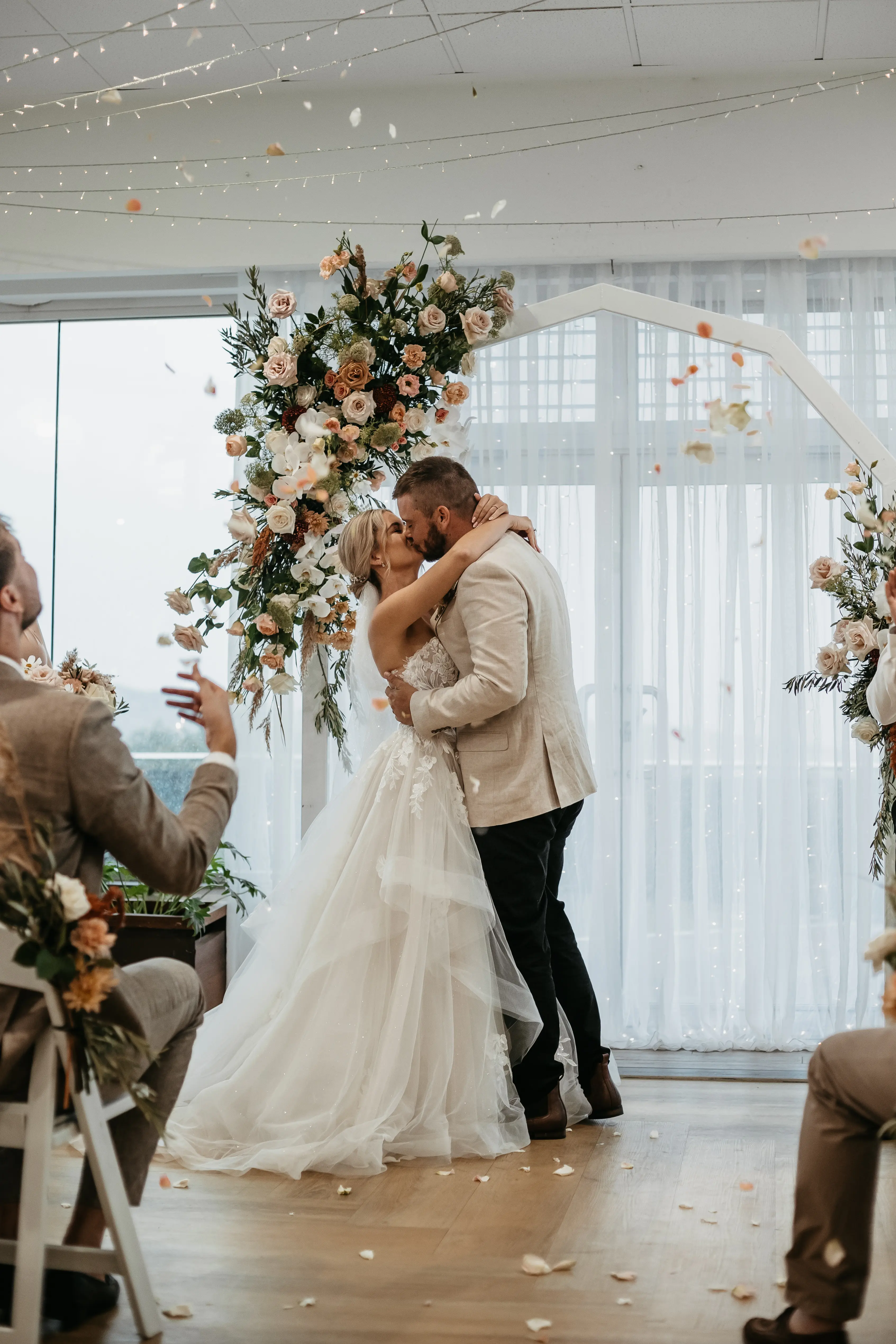 Bride wearing Indiana by Maggie Sottero kissing her husband at their ceremony