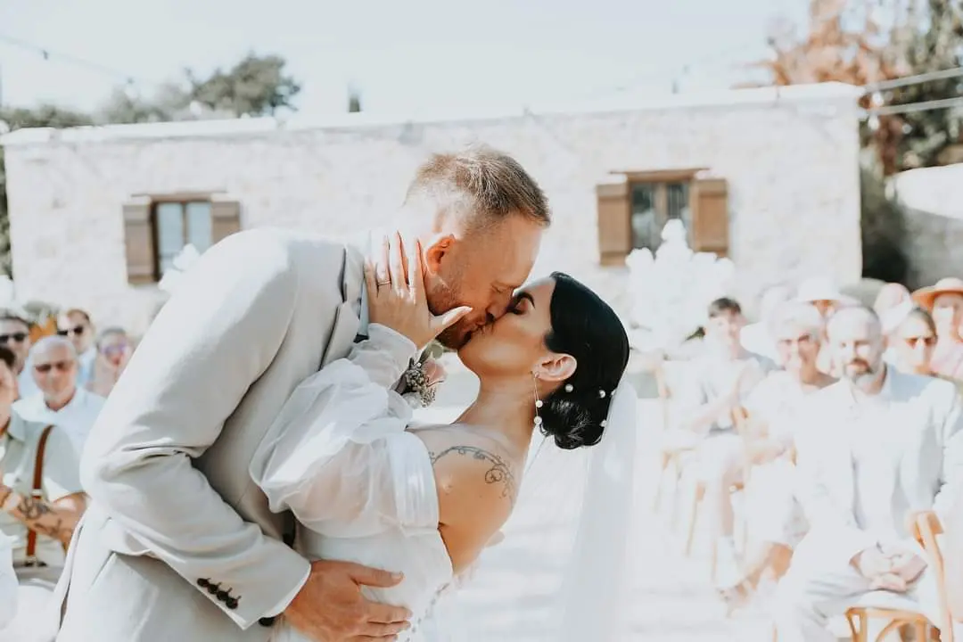 Bride Wearing Boho A-Line Wedding Dress Called Nerida By Sottero And Midgley Kissing Groom