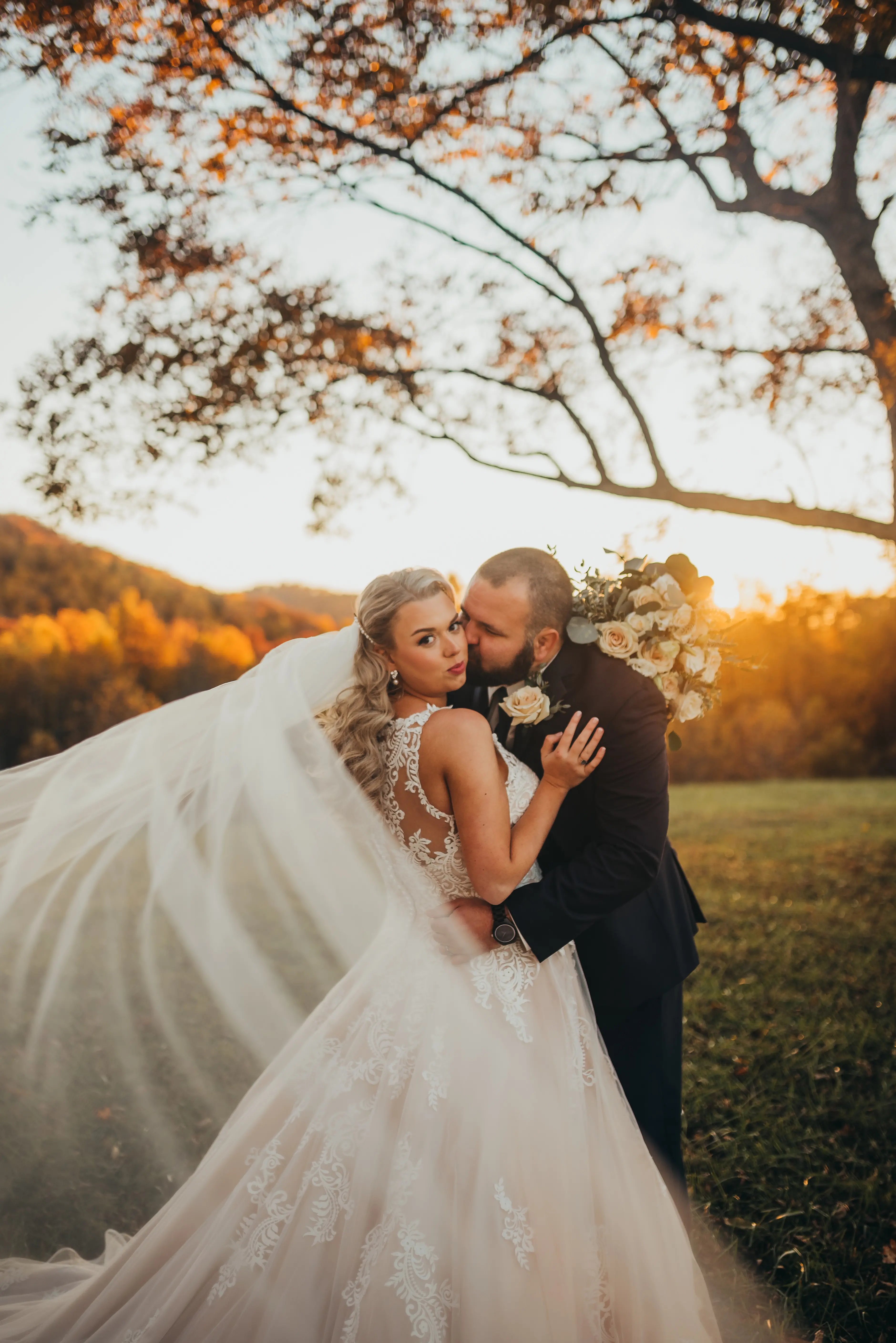 Bride with groom wearing a plus size ballgown wedding dress.