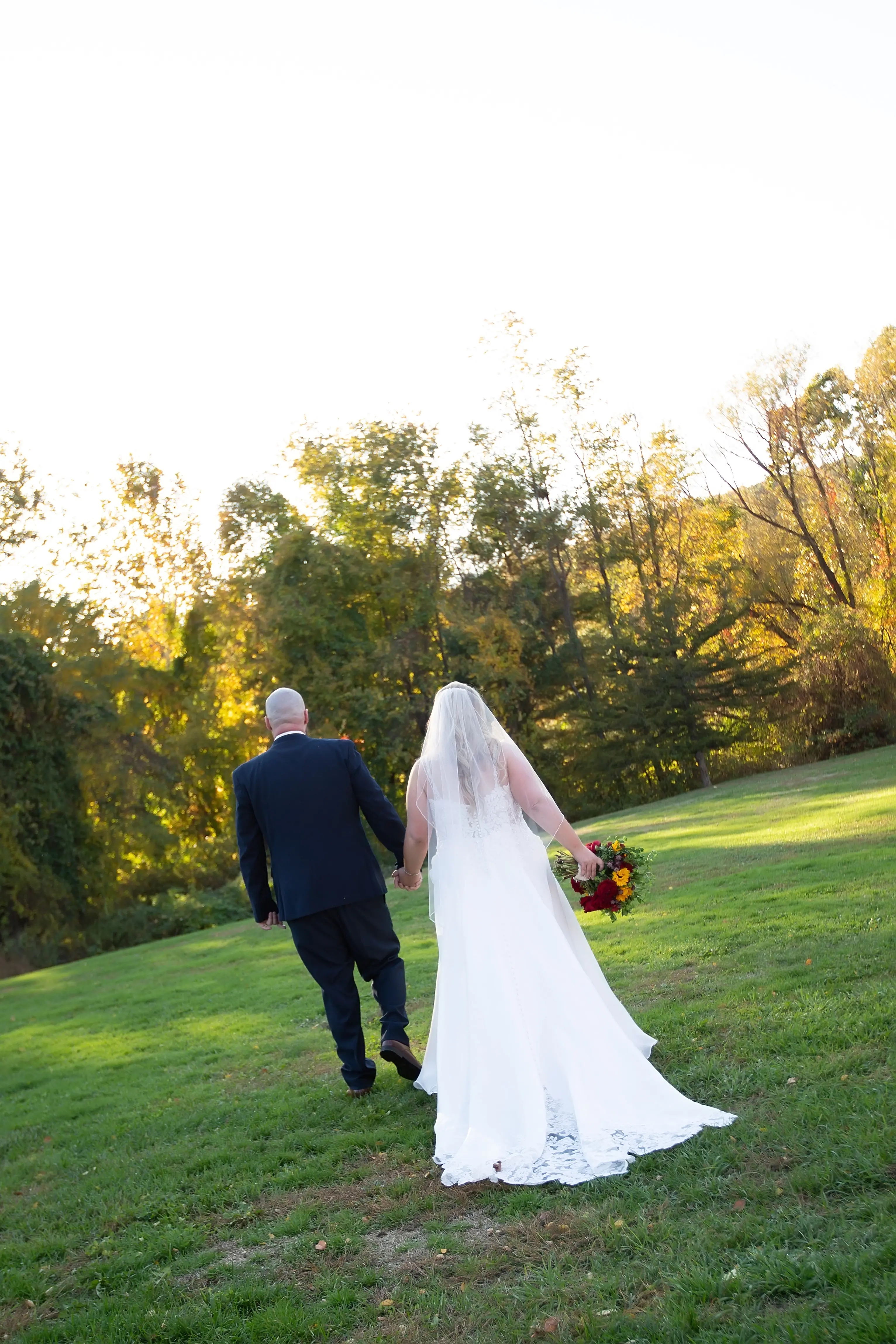 Groom Holding Hands with Bride in Wedding Dress Called Savannah by Maggie Sottero.