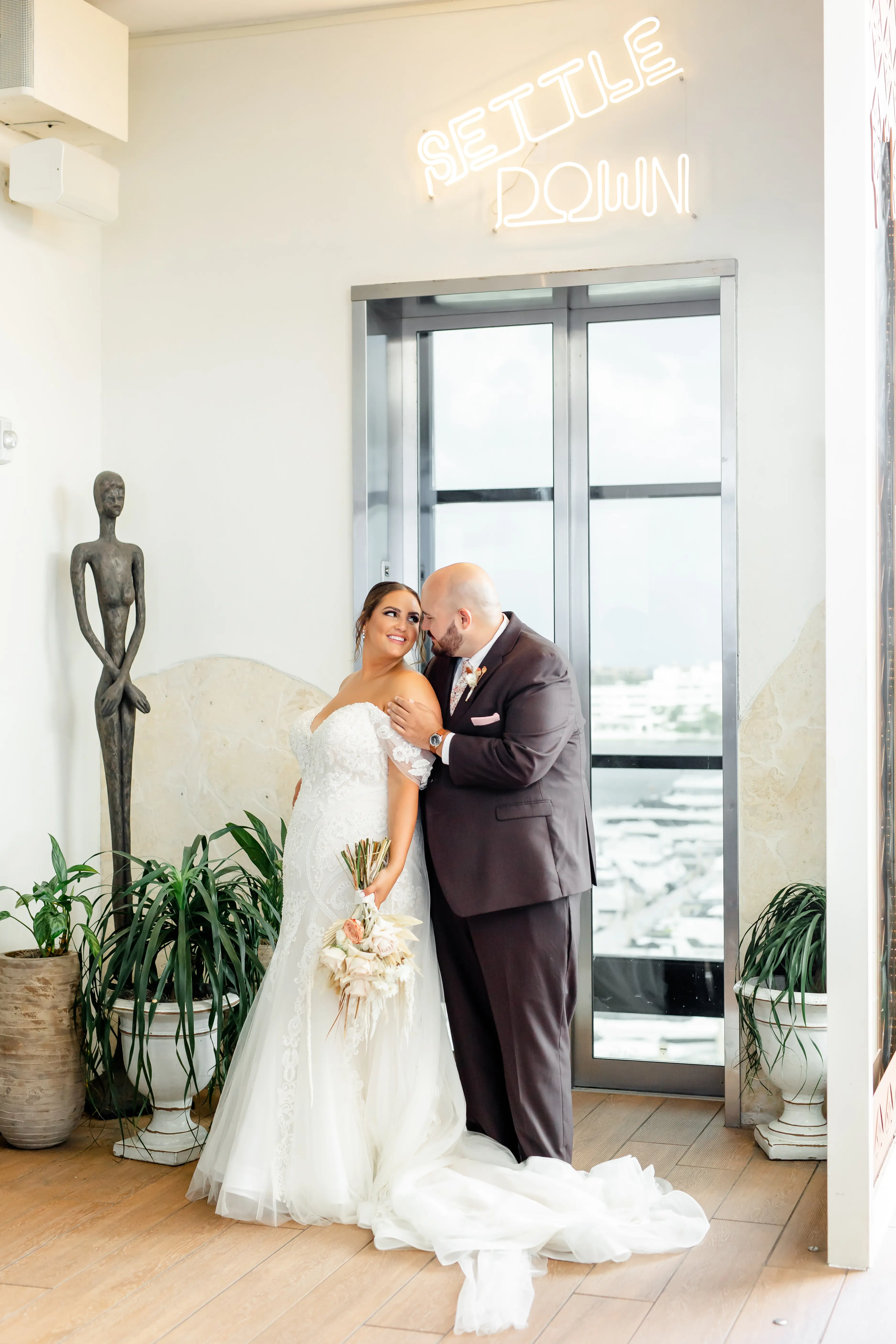 Bride with groom wearing off-the-shoulder mermaid wedding dress.