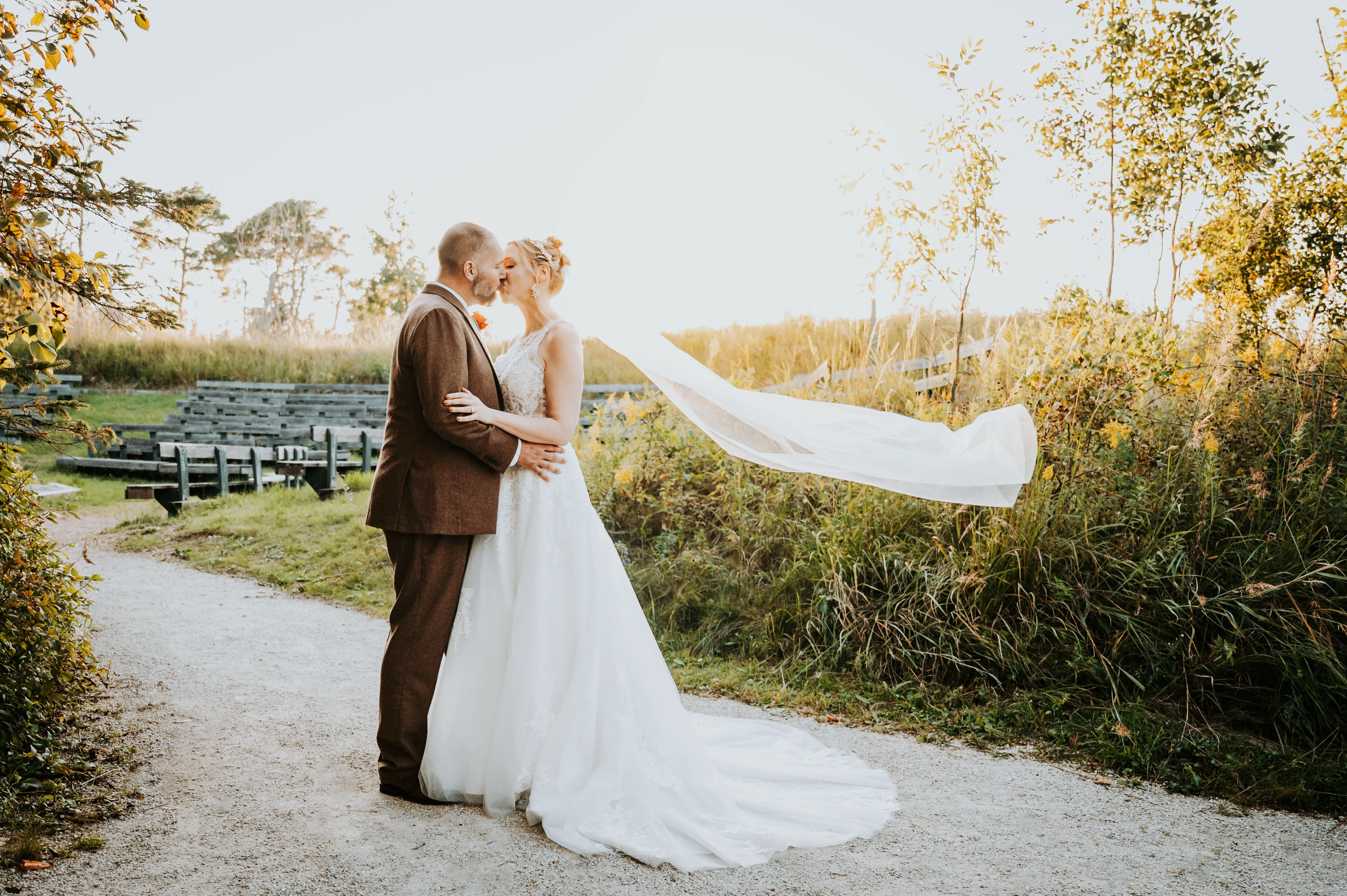 Bride wearing Lace Aline Wedding Dress Called Rickie By Rebecca Ingram Kissing The Groom