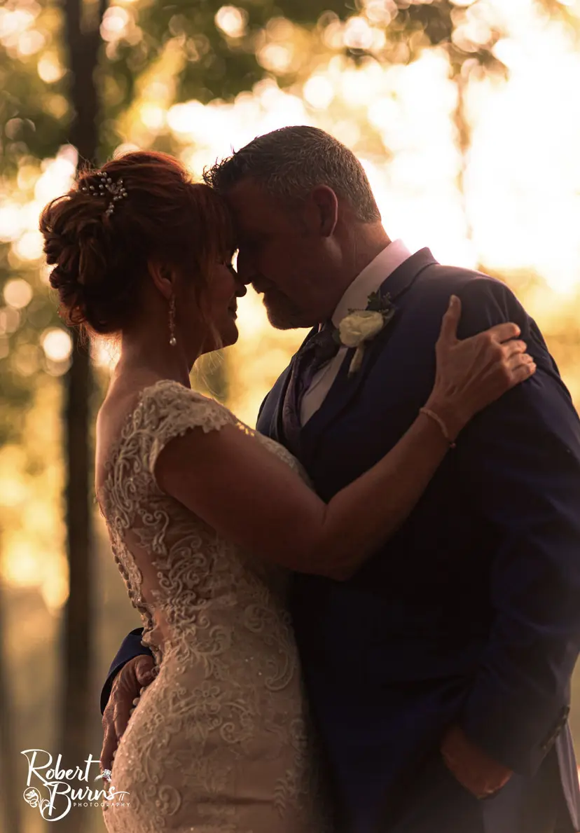 Groom and Bride Bride at Outdoor Wedding Wearing a Lace Bridal Dress Called Daphne Lynette by Rebecca Ingram