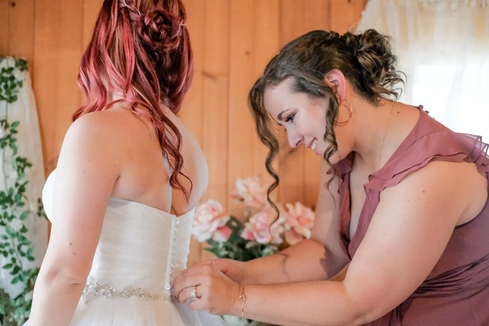 Bride Wearing Sparkly Princess Ballgown Wedding Dress Called Yasmin By Maggie Sottero Getting Buttoned Up By Bridesmaid