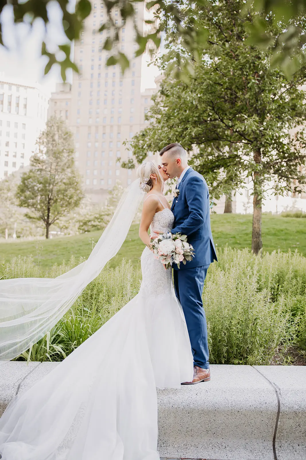 Groom kissing his bride who is wearing wedding dress called Alistaire.