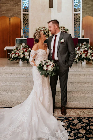Groom Gazing Lovingly at Bride in Sparkly Lace Fit-and-Flare Bridal Dress with Off-the-Shoulder Sleeves Called Fiona by Maggie Sottero