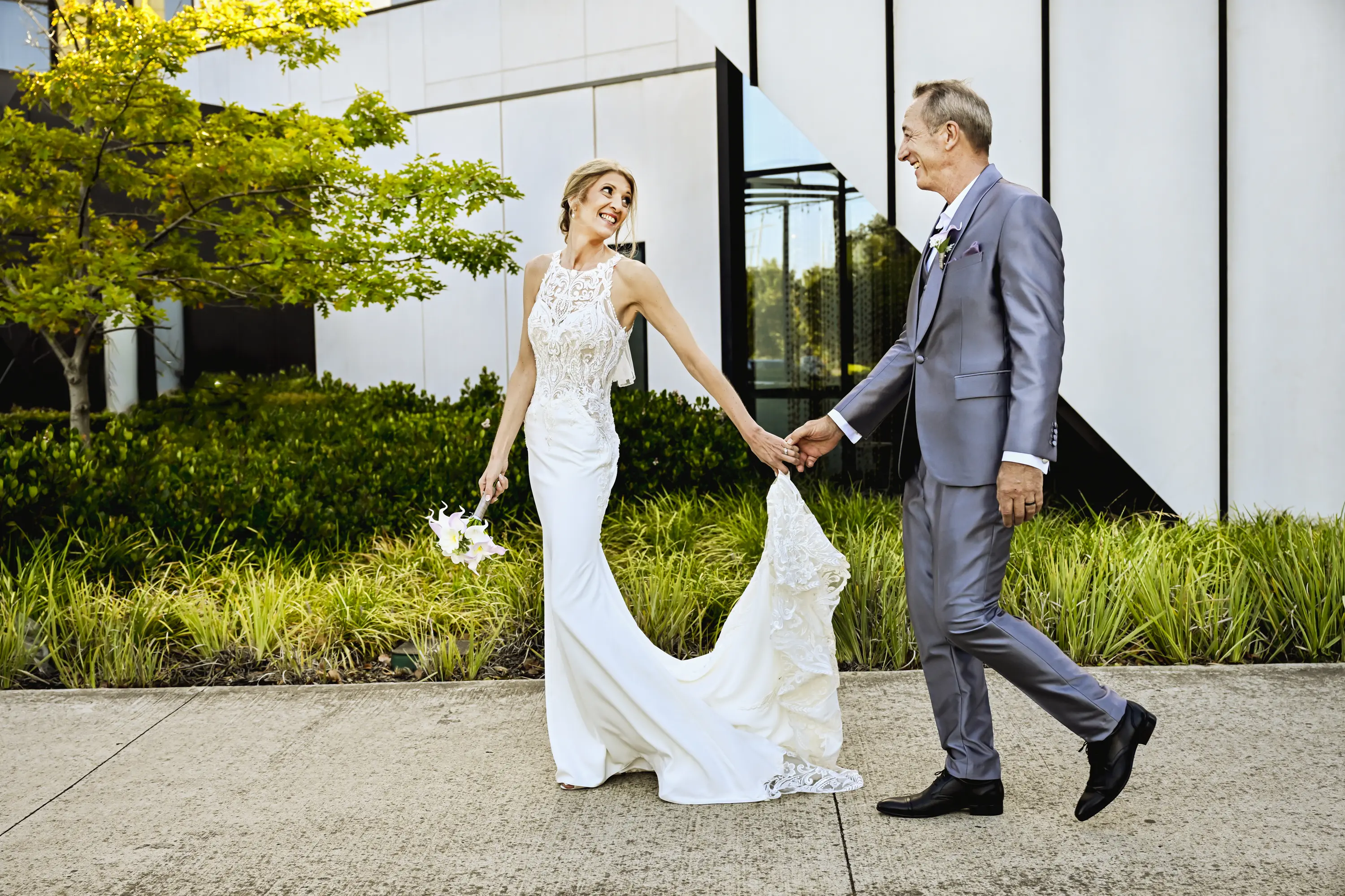 Bride wearing Audrina by Maggie Sottero holding hands with her husband