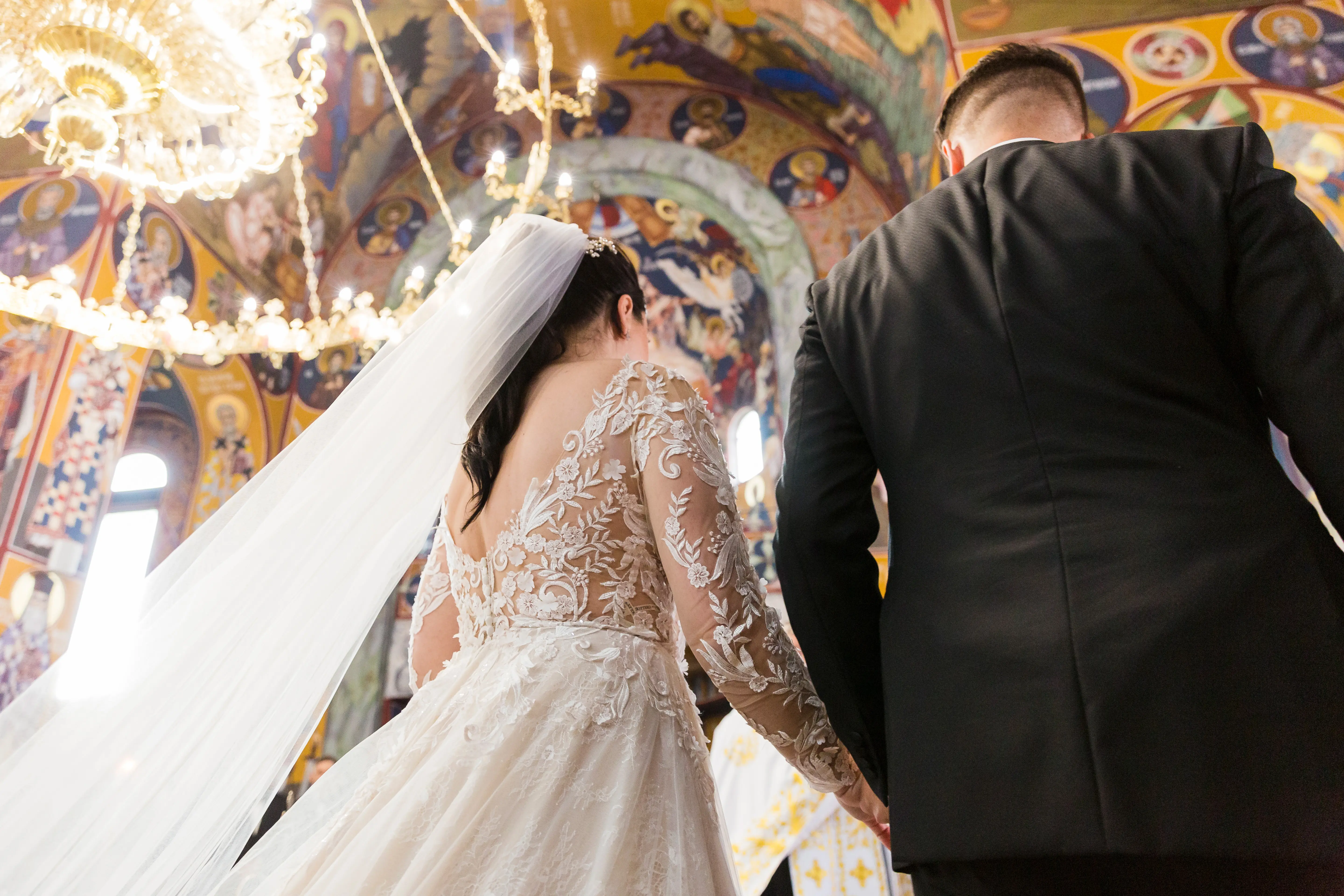 Bride wearing Zander by Sottero and Midgley holding hands with her husband