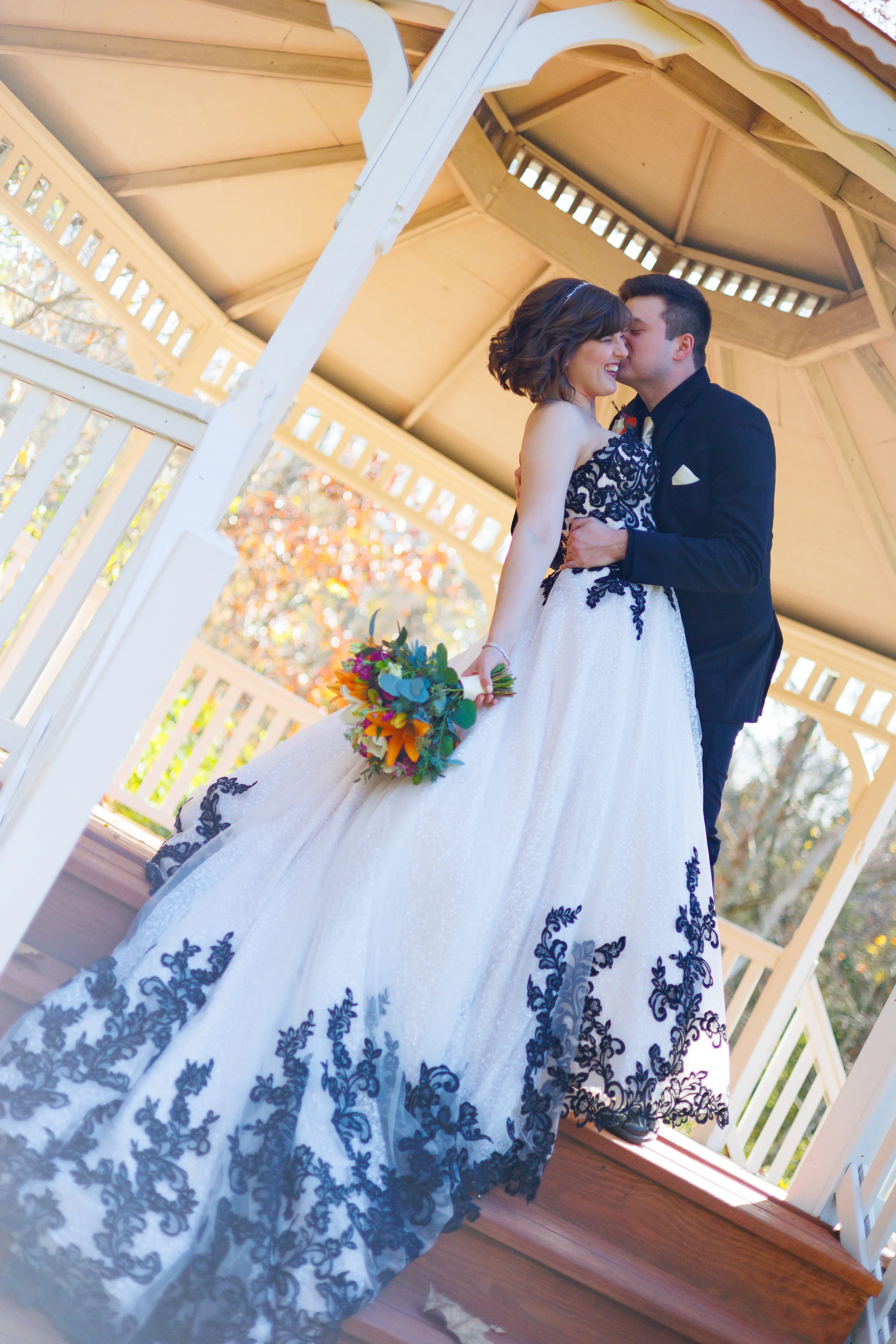 Bride And Groom Standing Together. Bride Wearing Black And White Lace Strapless Ball Gown Called Tristyn By Maggie Sottero