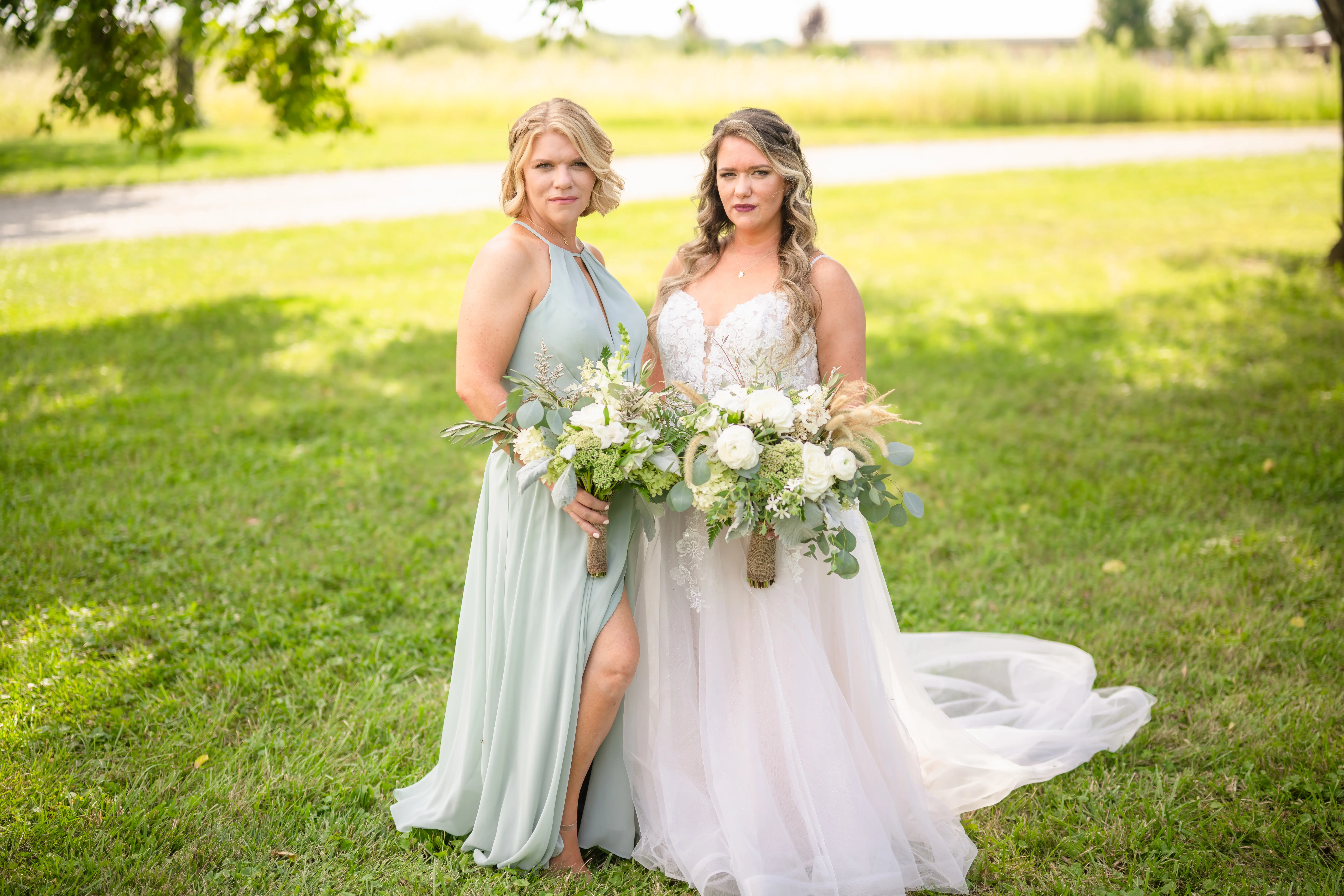 Bride Wearing Lace Princess Wedding Dress Called Stevie By Maggie Sottero With A Bridesmaid Both Making A Smolder Face