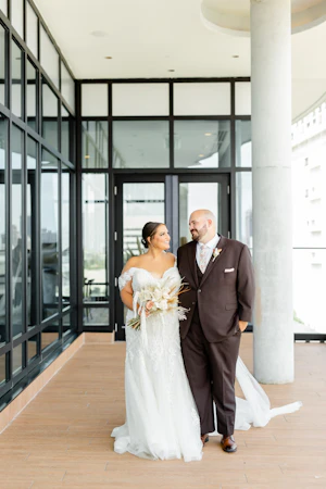 Bride with groom wearing off-the-shoulder mermaid wedding dress.