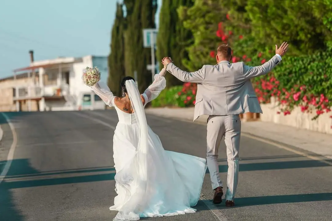 Bride Wearing Boho A-Line Wedding Dress Called Nerida By Sottero And Midgley Cheering With Groom