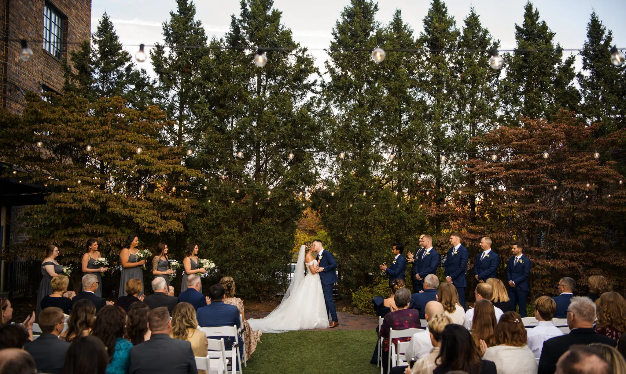 Bride wearing Harlem wedding dress by Maggie Sottero kissing the groom at their ceremony