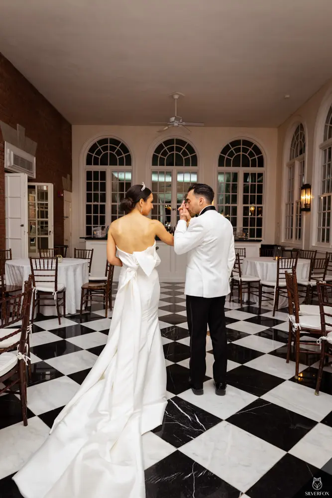 Bride And Groom Standing Together. Bride Wearing Unique Strapless Wedding Gown With Statement Bow Called Mitchell By Maggie Sottero