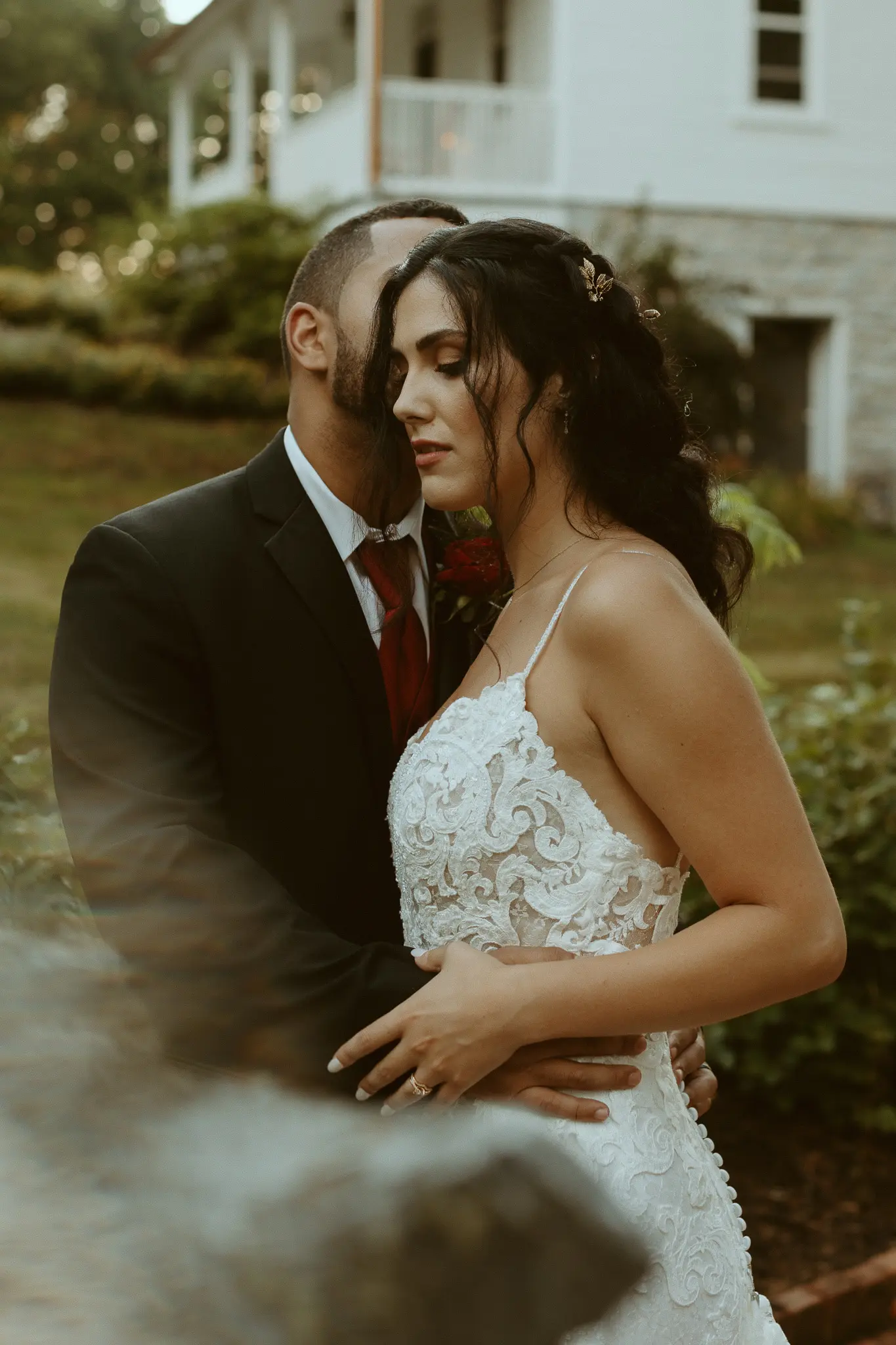 Bride with groom wearing lace sheath wedding dress.