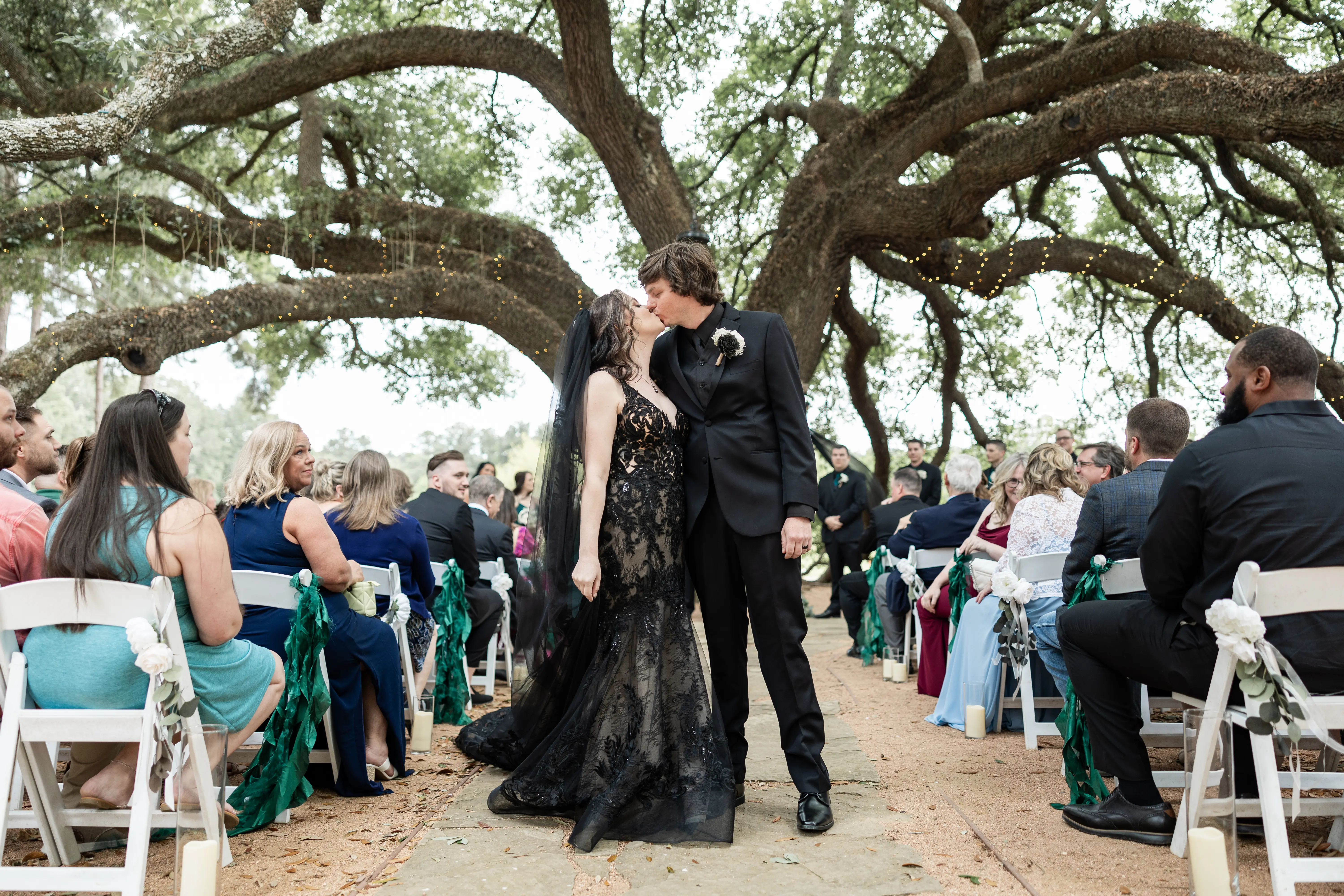Bride wearing Zander Lane by Sottero and Midgley kissing her husband during their ceremony
